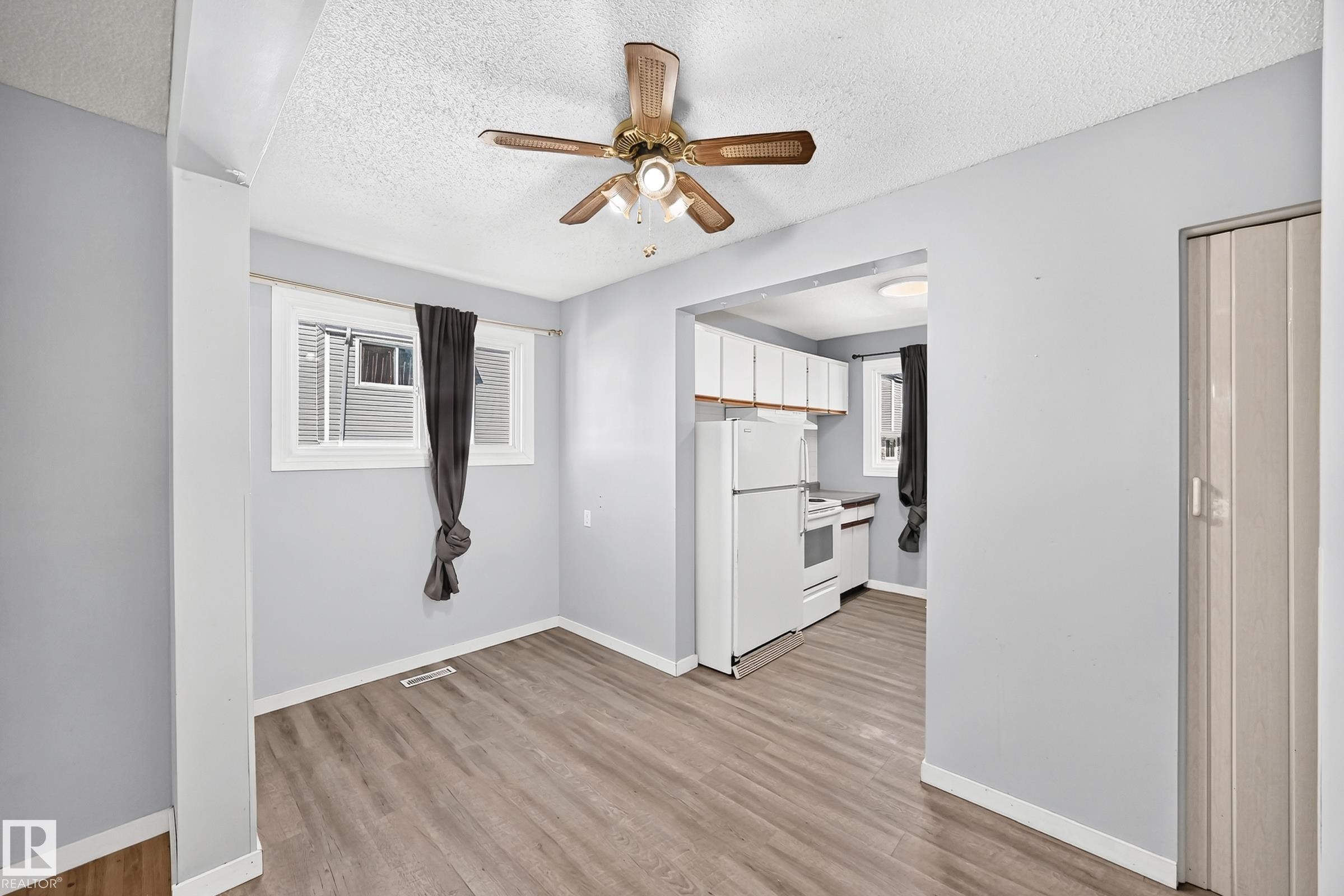 Open-concept room featuring wood-finish flooring, light gray wall paint, and a ceiling fan - 355 Northgate Terrace, Edmonton, AB