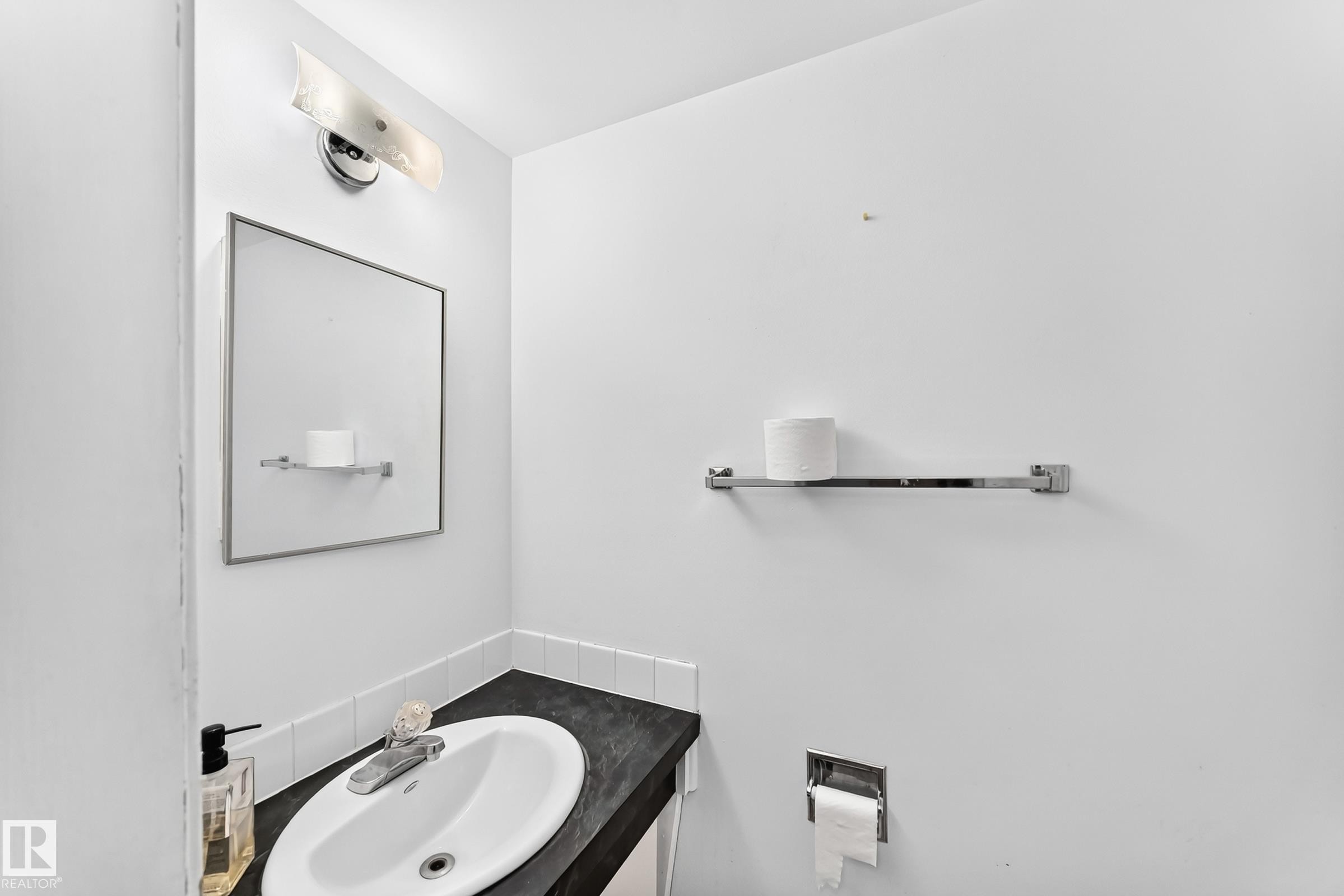 Integrated vanity with a dark countertop and white oval sink - 355 Northgate Terrace, Edmonton, AB