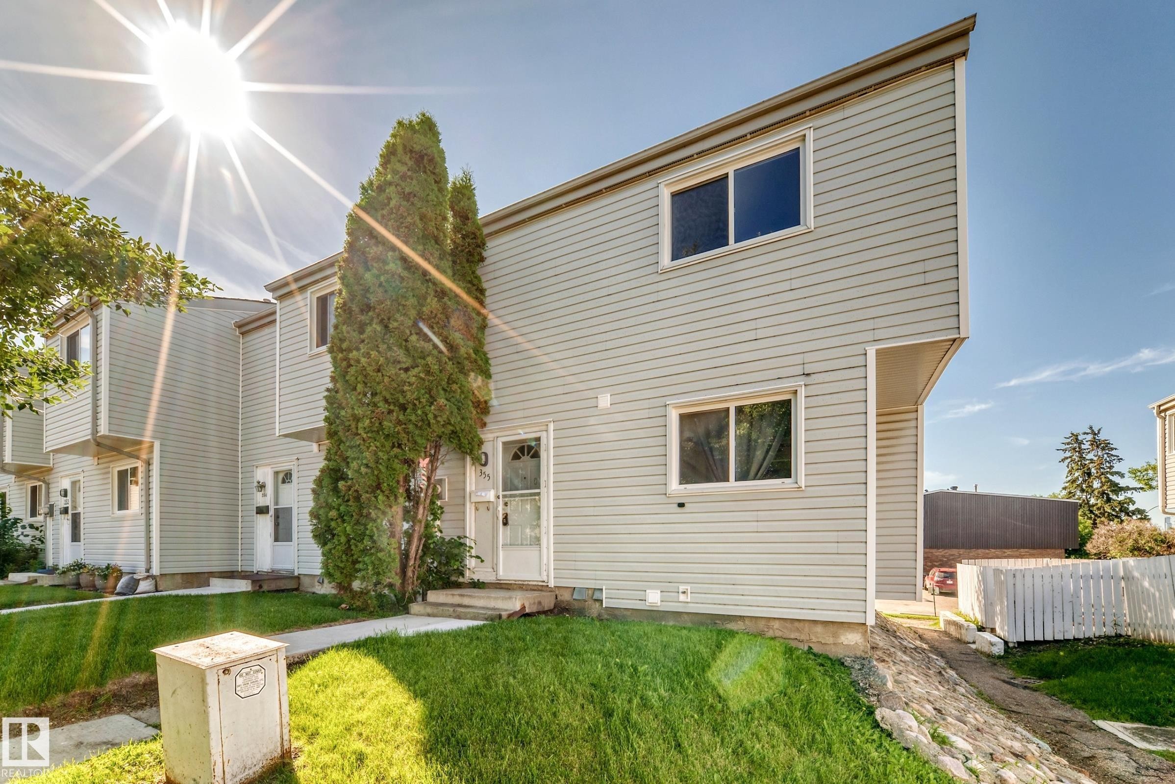 Multi-level townhouse exterior featuring light gray horizontal siding and a sloped roofline - 355 Northgate Terrace, Edmonton, AB