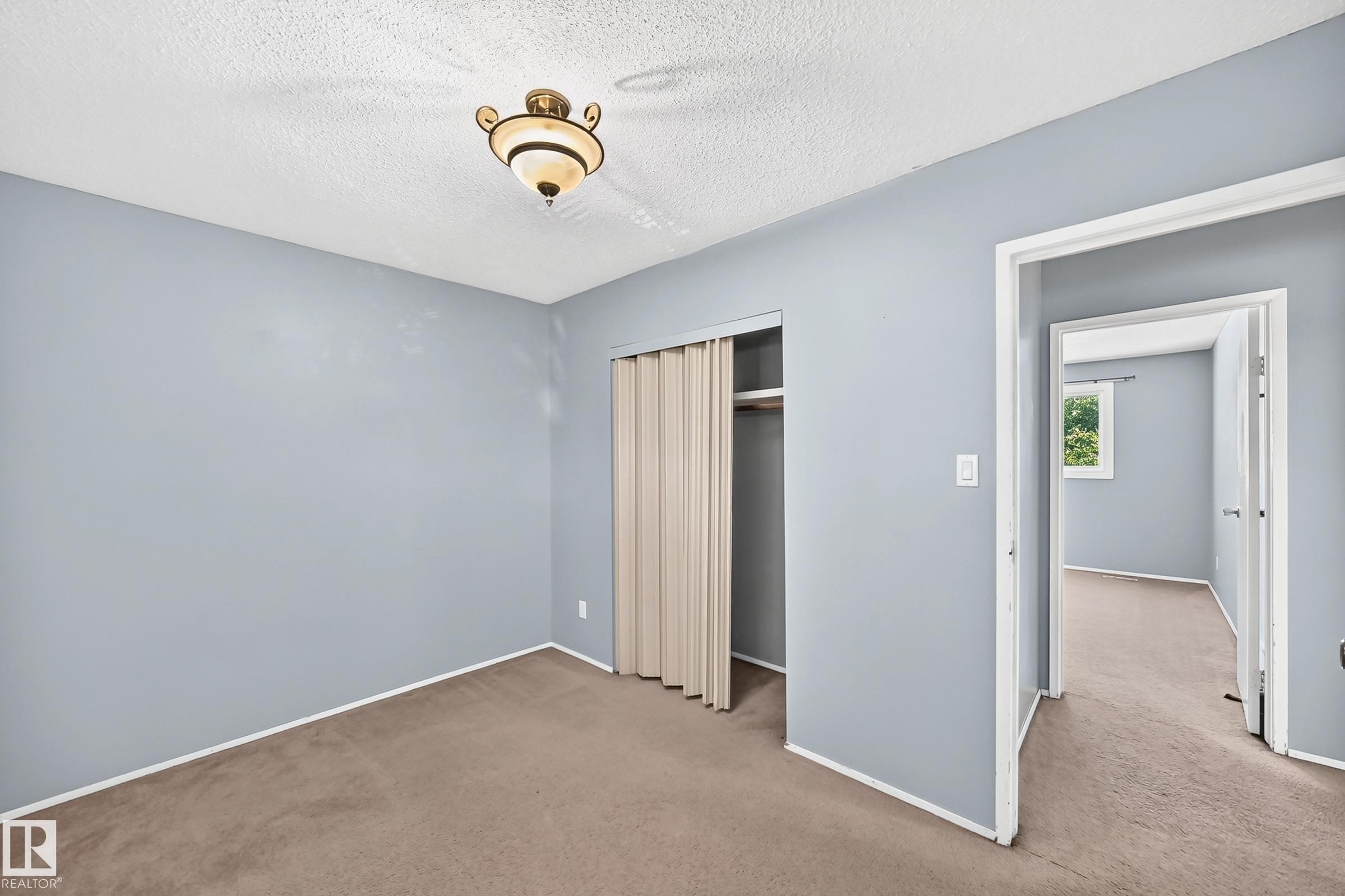 Room featuring neutral carpeting, light blue wall paint, and a textured ceiling - 355 Northgate Terrace, Edmonton, AB