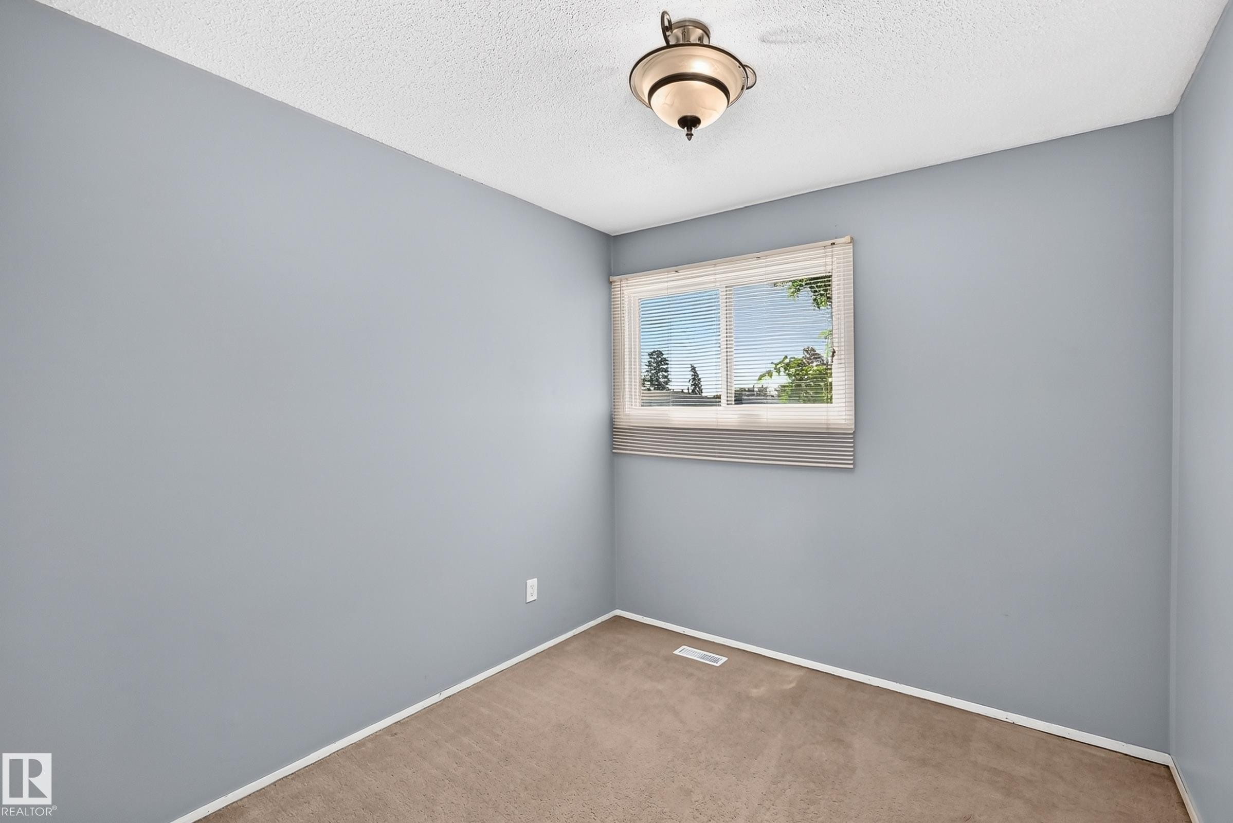 Room featuring light blue walls, a white popcorn ceiling, and a single window with white blinds - 355 Northgate Terrace, Edmonton, AB