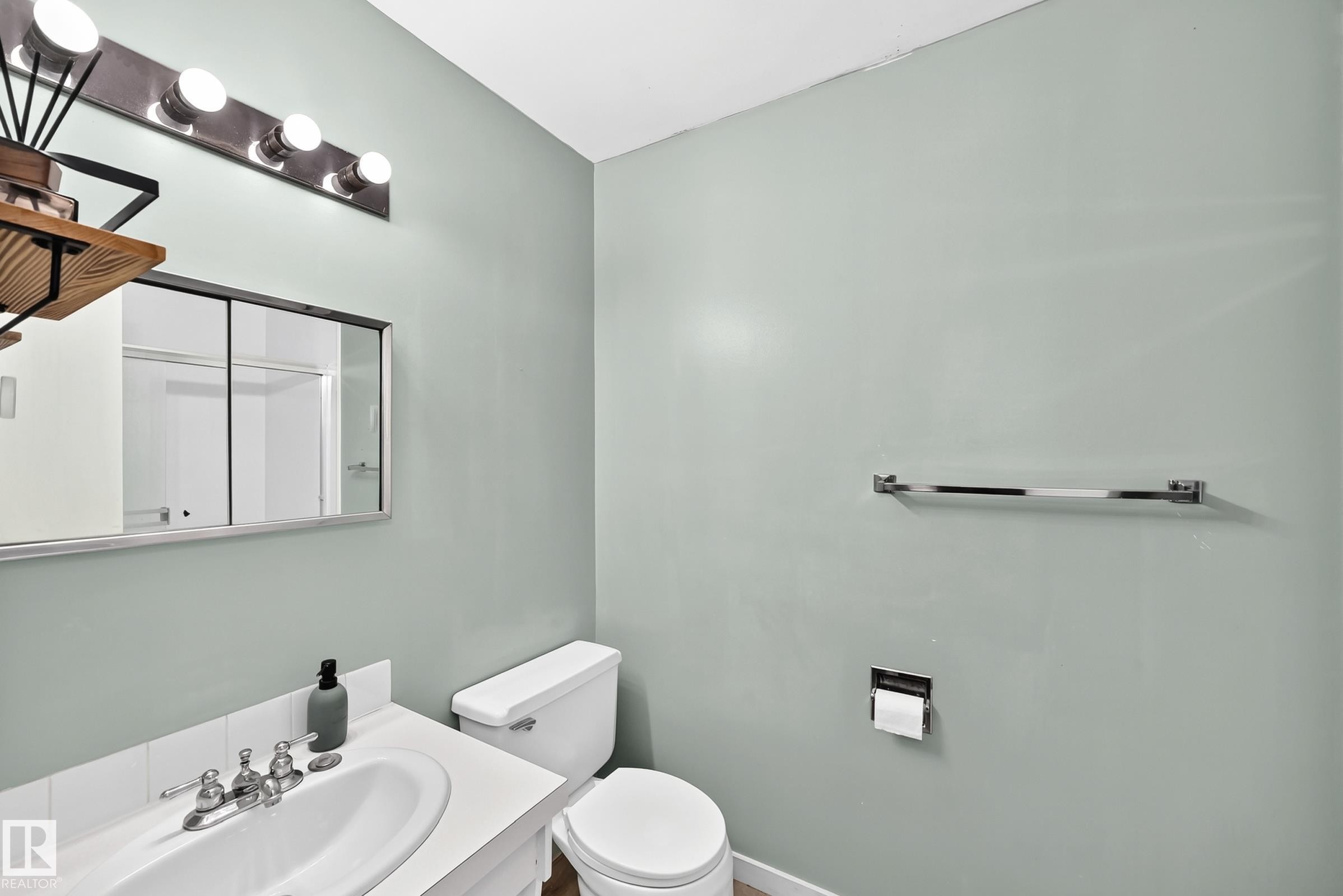 Bathroom featuring a white ceramic sink with chrome faucet, a mirrored medicine cabinet, and a five-bulb vanity light fixture - 355 Northgate Terrace, Edmonton, AB
