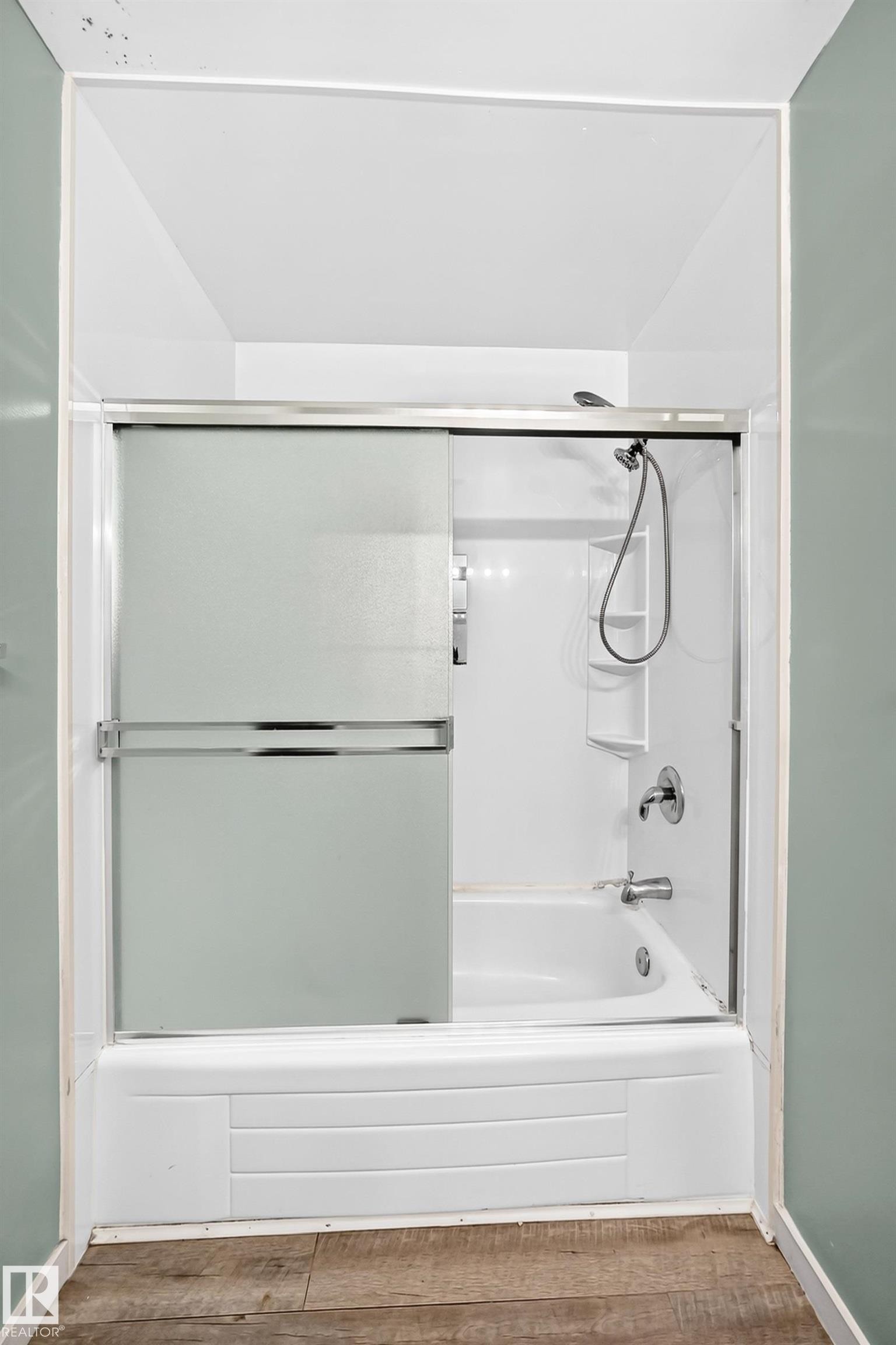 Bathtub with integrated shower, frosted glass sliding doors, and a chrome shower fixture - 355 Northgate Terrace, Edmonton, AB