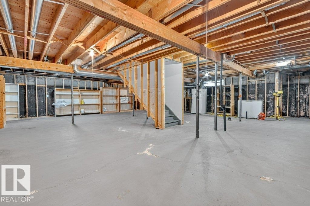 Expansive unfinished basement featuring exposed wood joists and beams, a concrete floor, framed wall partitions, and an exposed utility system - 16524 99 Street Nw, Edmonton, AB - Indoor Photo Showing Basement