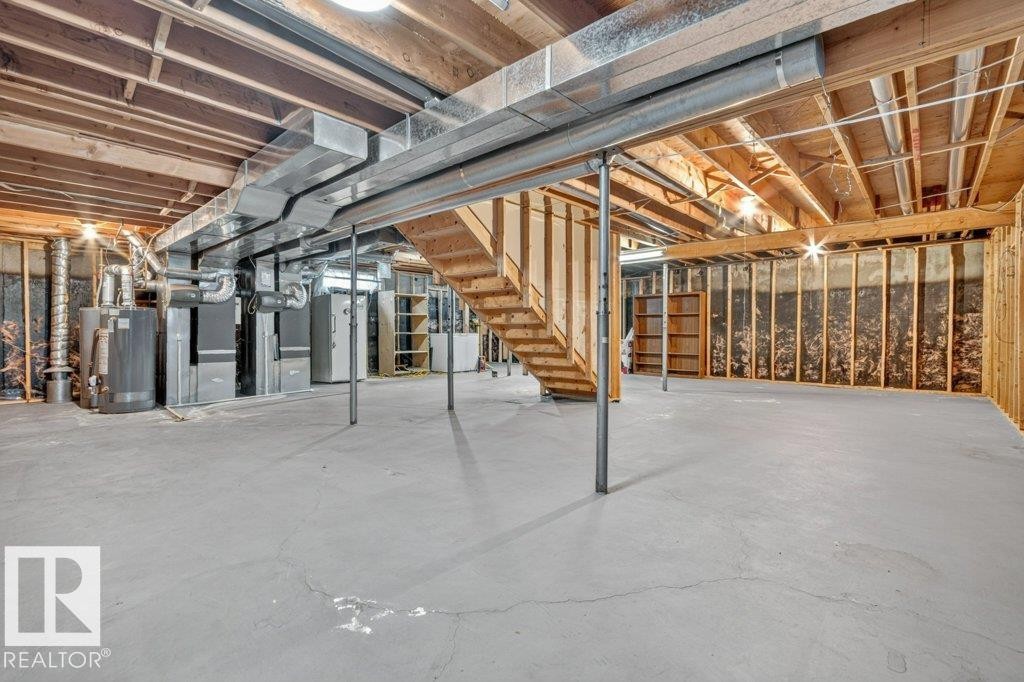 Spacious unfinished basement offering extensive potential for customization, featuring exposed ceiling joists, substantial open floor space, and visible HVAC ductwork - 16524 99 Street Nw, Edmonton, AB - Indoor Photo Showing Basement