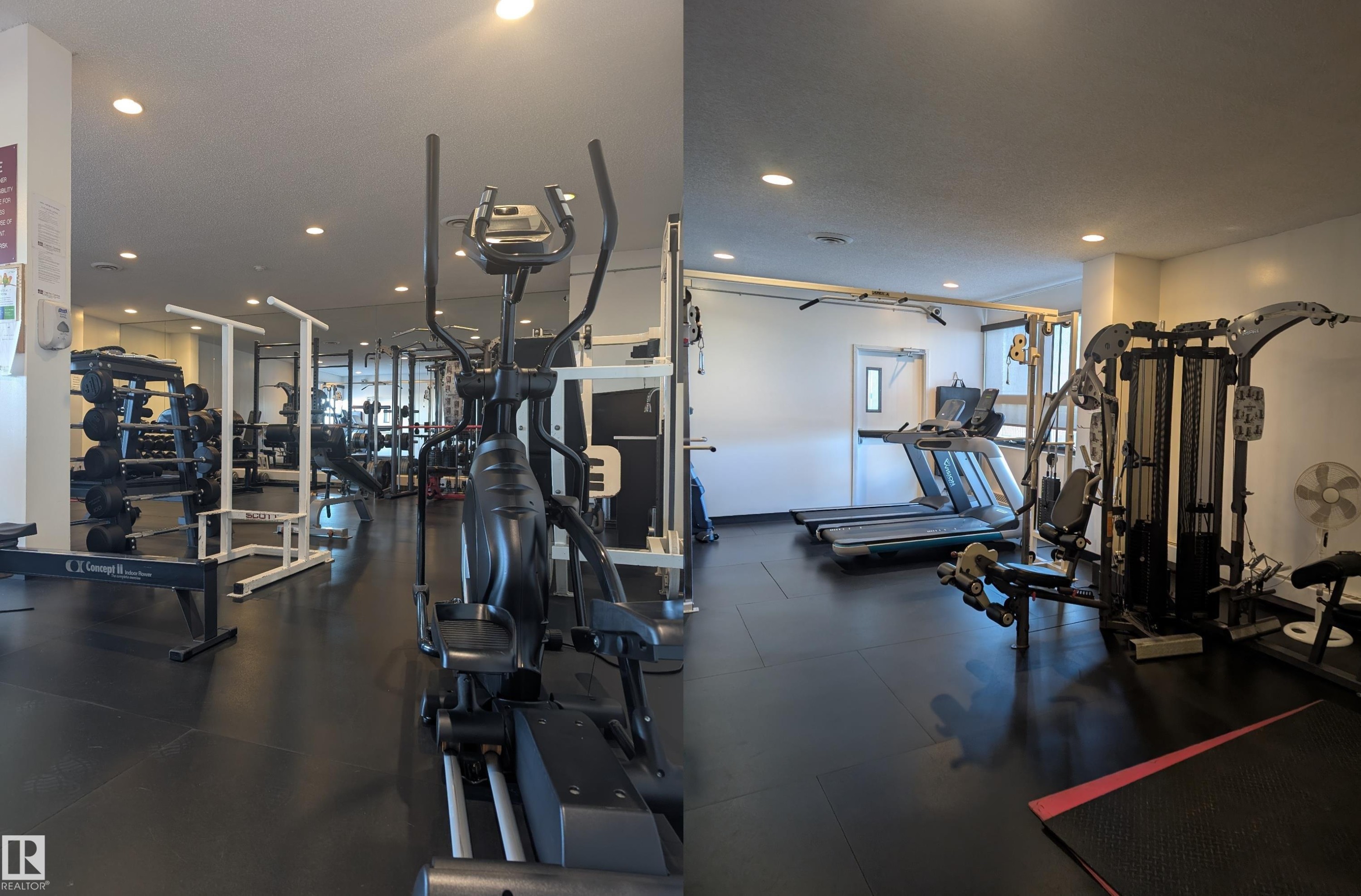 Fitness center featuring black rubber flooring, recessed lighting, and a variety of exercise equipment including an elliptical, treadmills, and a multi-station weight machine - 505 10145 109 Street, Edmonton, AB