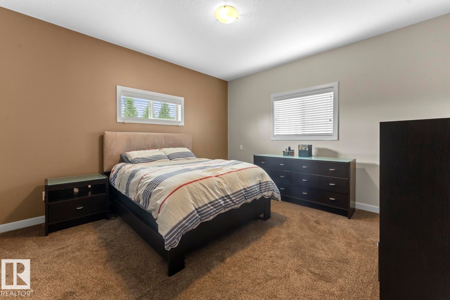 Carpeted interior space featuring two windows with white blinds - 35 Falcon Road, Cold Lake, AB