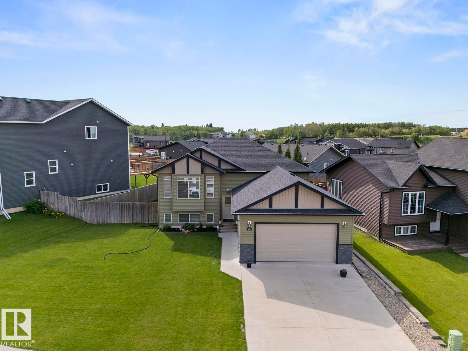 Contemporary split-level home featuring a two-car garage, concrete driveway, and a well-maintained lawn - 35 Falcon Road, Cold Lake, AB