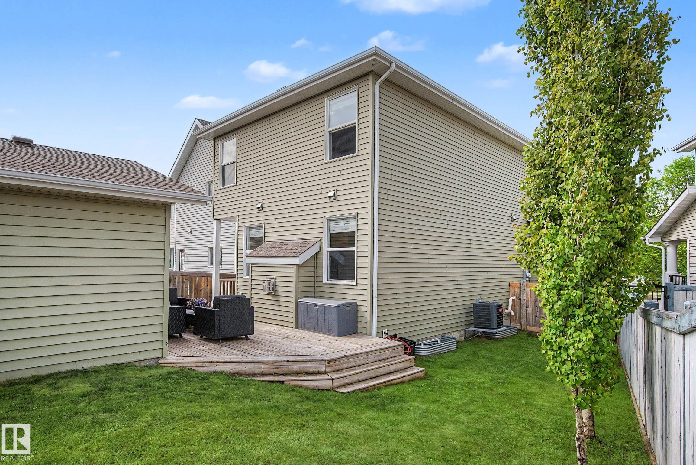 Rear exterior featuring a multi-level wood deck, a verdant lawn, and mature perimeter trees - 2007 72 Street, Edmonton, AB - Outdoor With Exterior