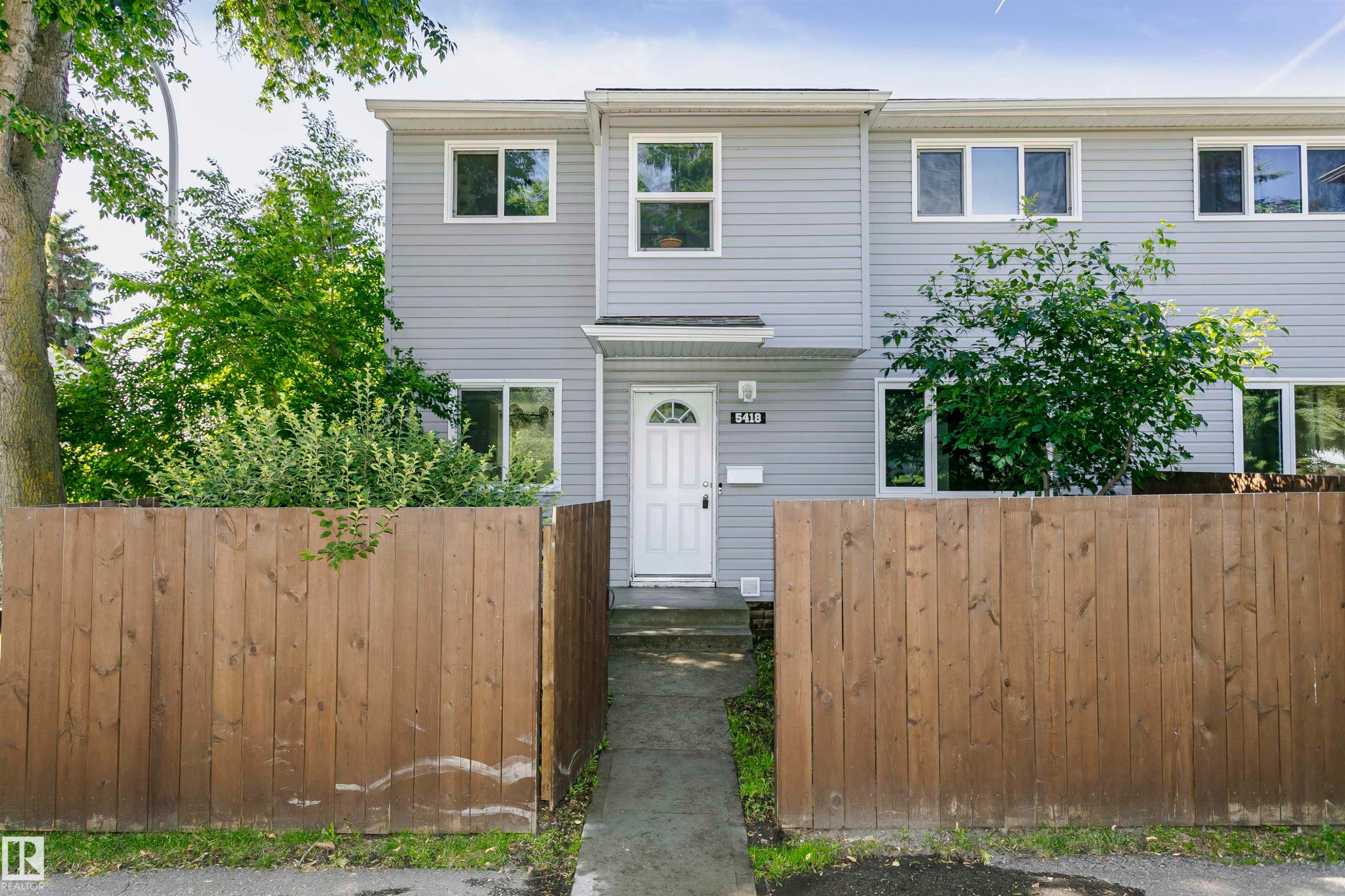 Two-story residential building with light gray horizontal siding and white trim - 5418 144B Avenue, Edmonton, AB