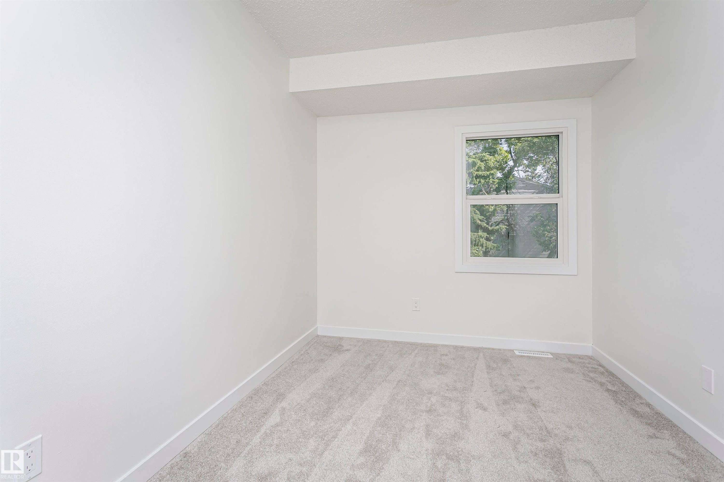 Neutral wall color with white trim, a double-hung window, and light gray carpet - 5418 144B Avenue, Edmonton, AB