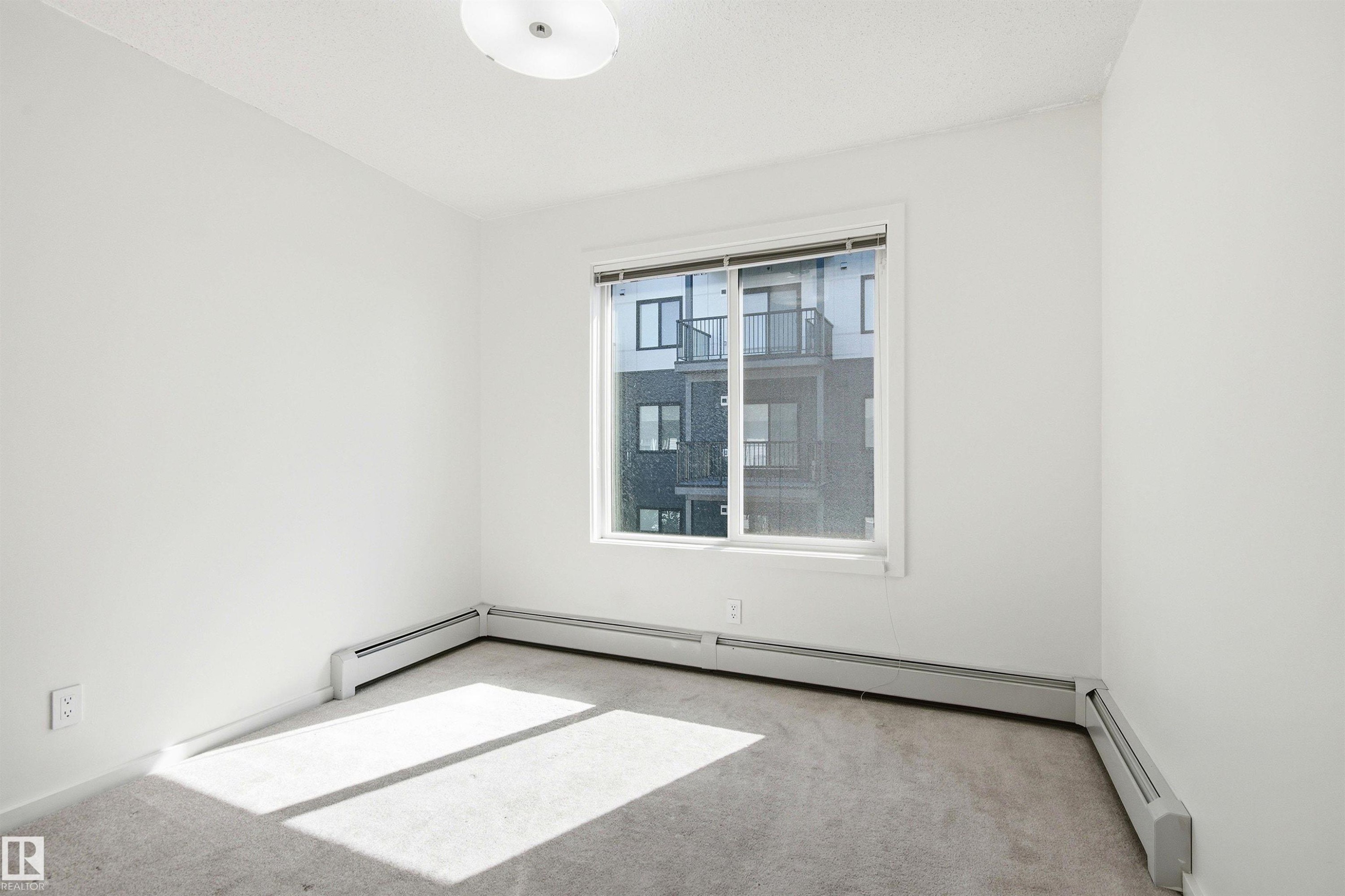 Neutral-toned carpeting complements bright white walls - 435 5515 7 Avenue, Edmonton, AB