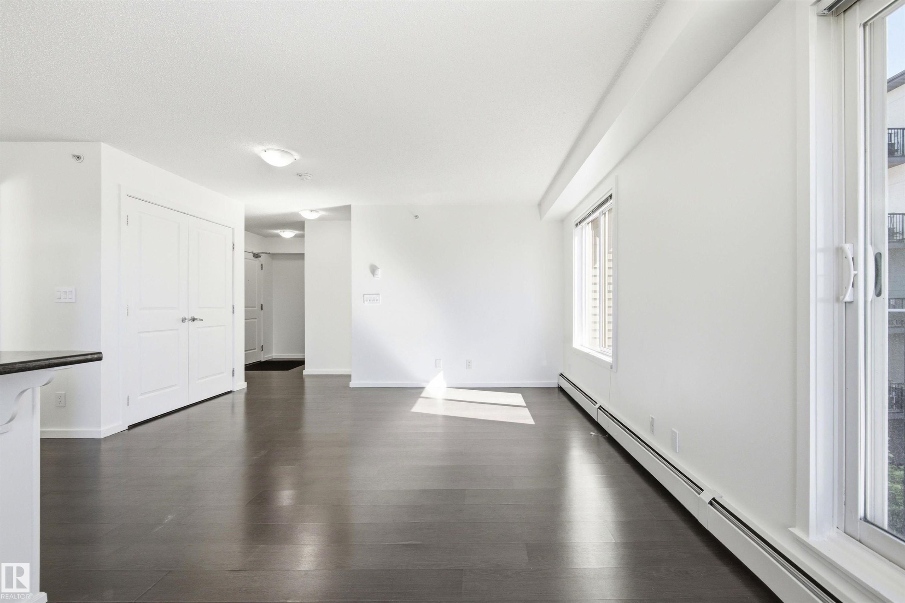 Bright living space featuring dark wood-finish flooring and white walls - 435 5515 7 Avenue, Edmonton, AB