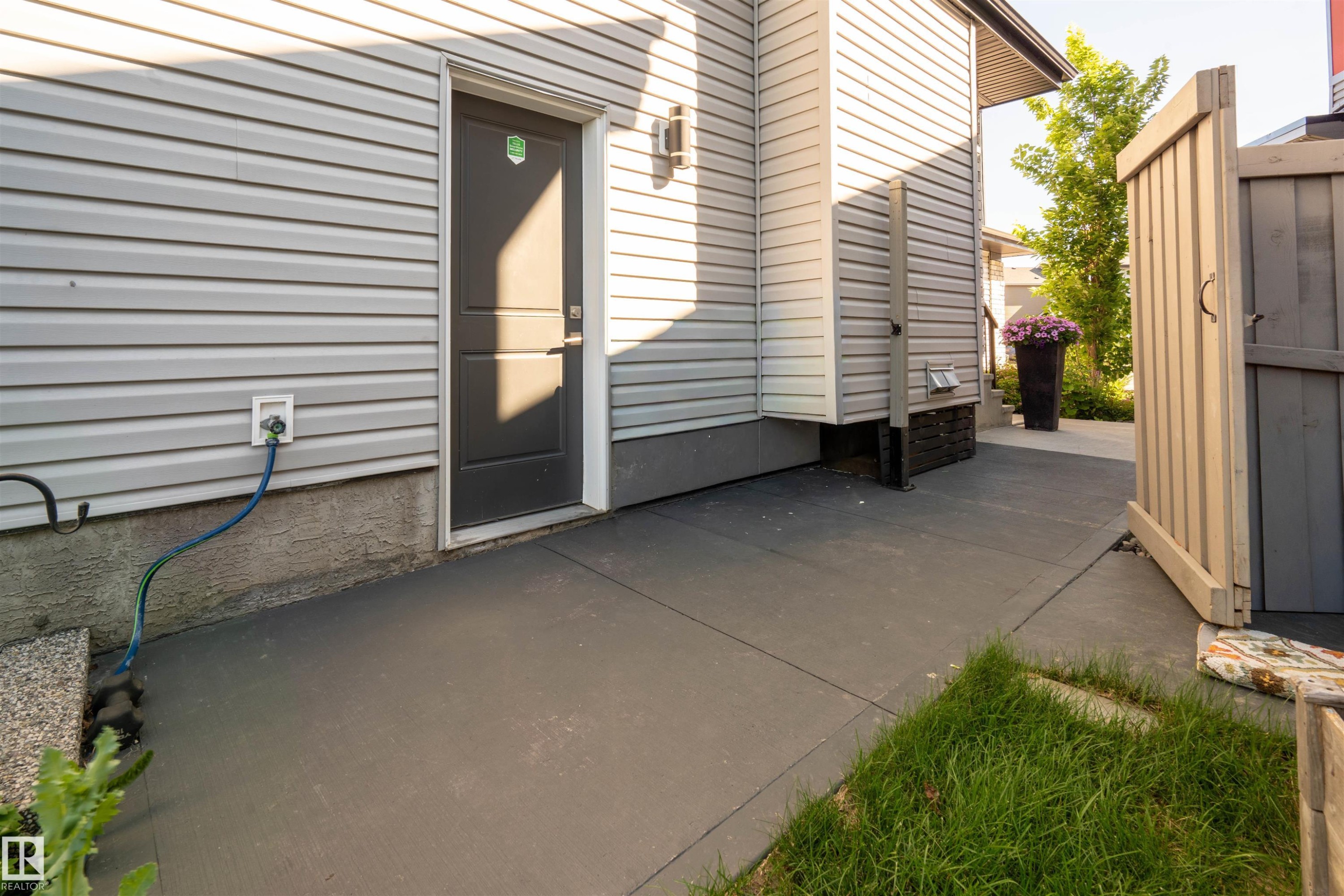 Gray painted concrete walkway leading to an exterior door - 4714 Charles Bay Bay, Edmonton, AB