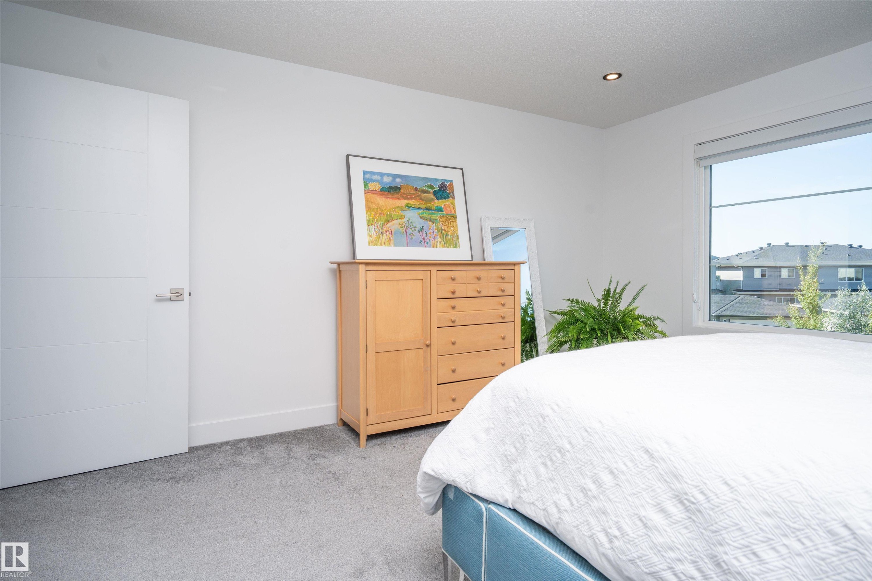 Light-filled interior featuring a large window, recessed lighting, white walls, and gray carpeting - 4714 Charles Bay Bay, Edmonton, AB