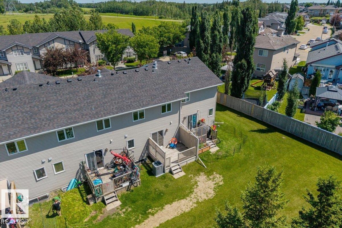 Rear exterior of a two-story residence featuring light gray siding and a dark gray shingle roof - 125 Birchwood Close, Devon, AB