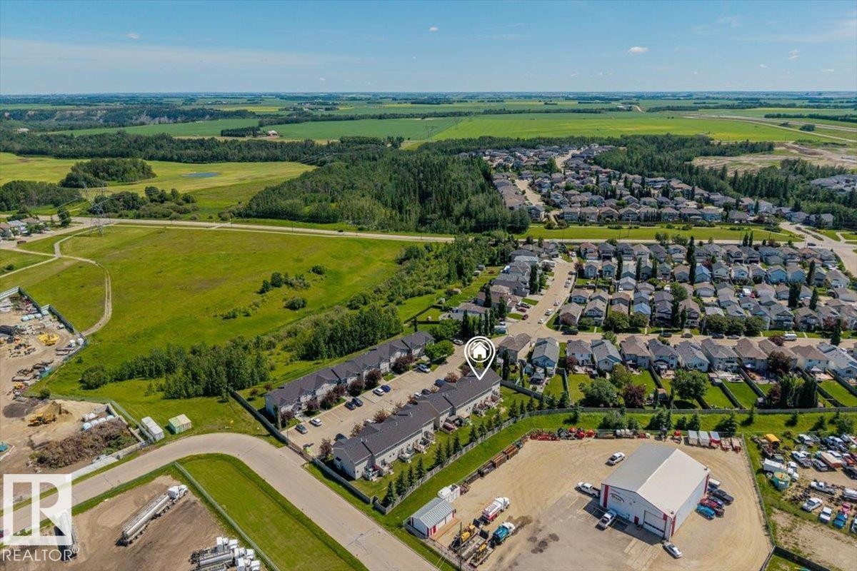 Aerial perspective showcasing the property within a residential development, bordered by expansive green spaces and fields - 125 Birchwood Close, Devon, AB