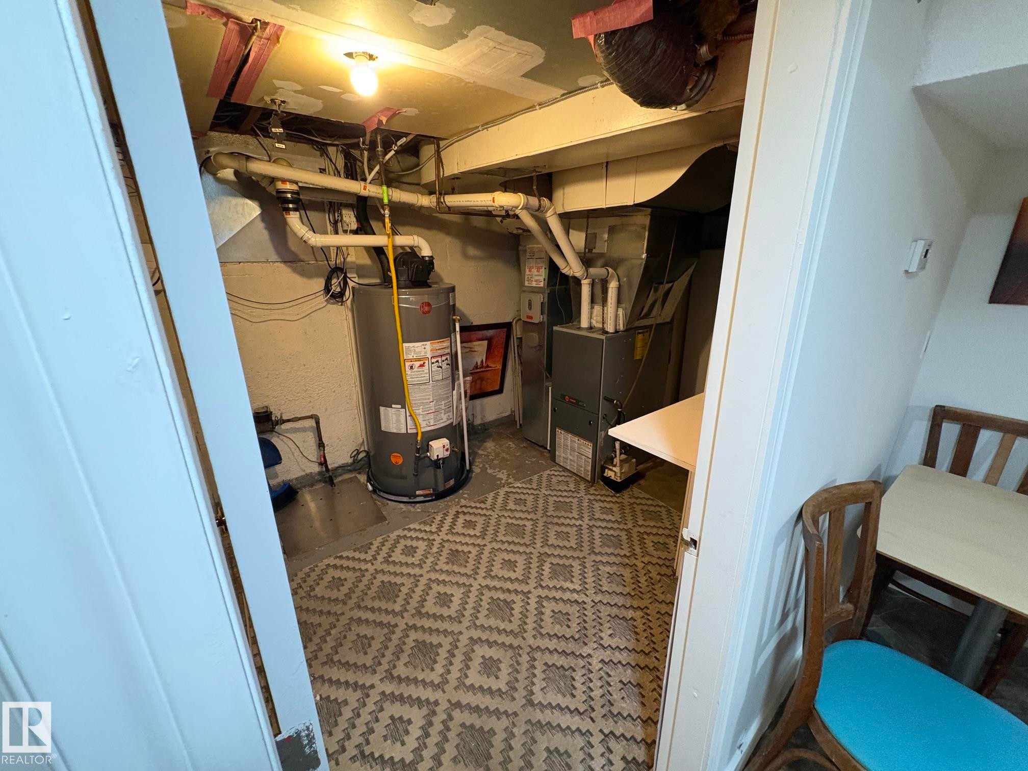 Utility area featuring a water heater, furnace, exposed ductwork, and patterned floor tile - 11511 101 Street, Edmonton, AB