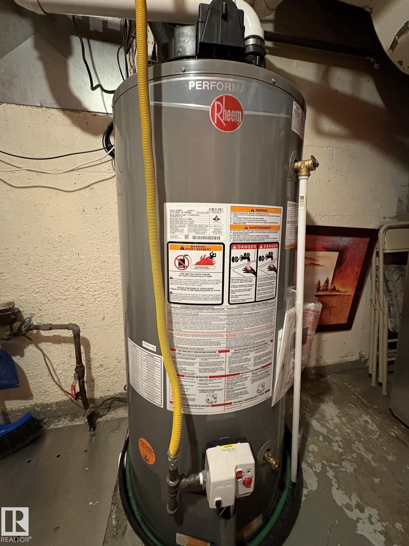 Rheem Performance water heater with yellow gas line, white PVC venting, and associated plumbing - 11511 101 Street, Edmonton, AB