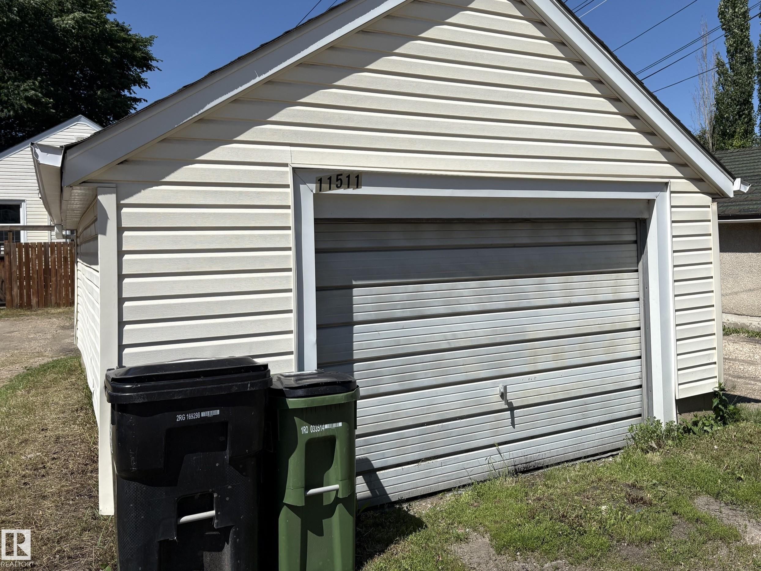 Detached garage featuring horizontal siding and a roll-up garage door - 11511 101 Street, Edmonton, AB