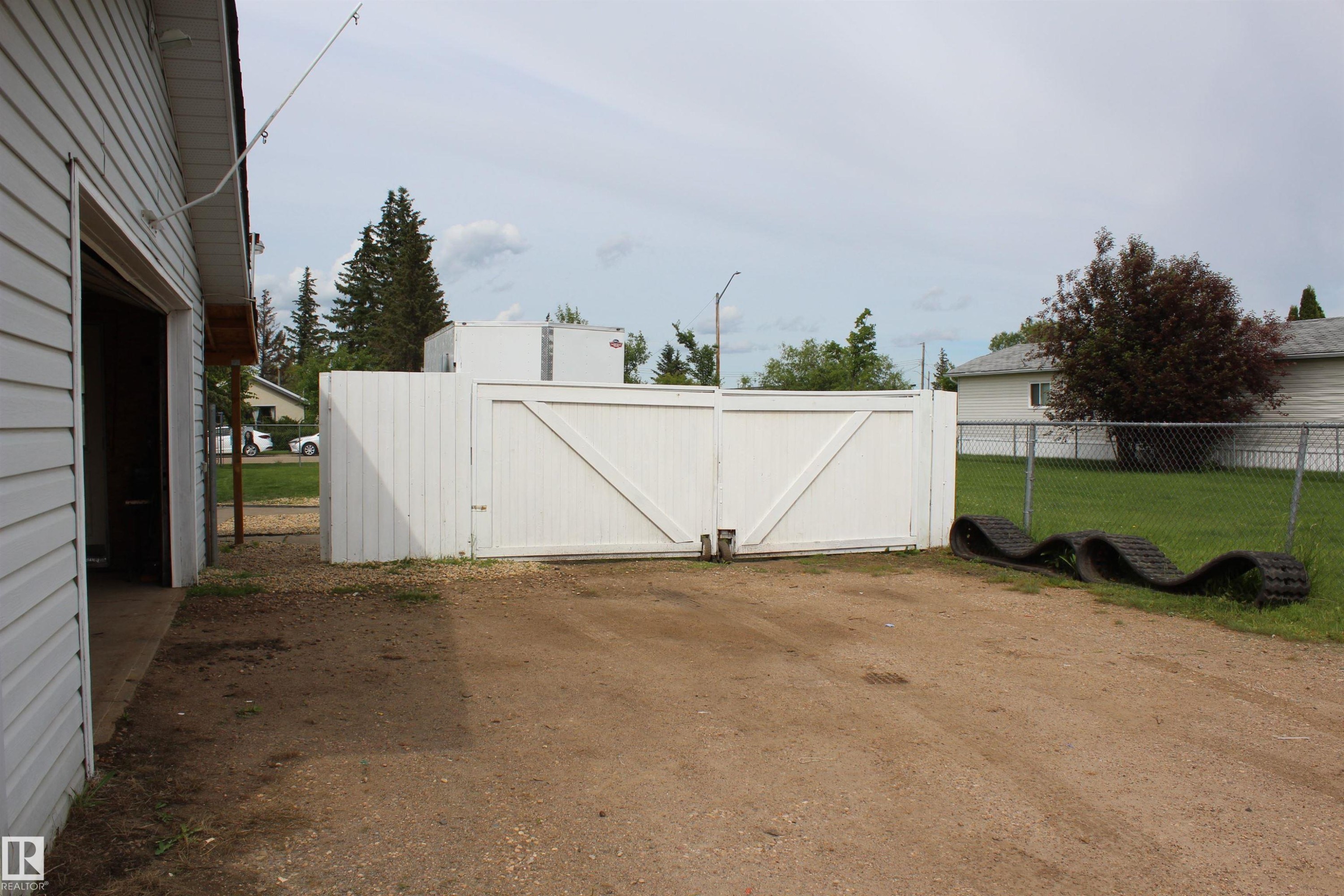 White privacy fence with double gates - 4839 49 Avenue, Chipman, AB