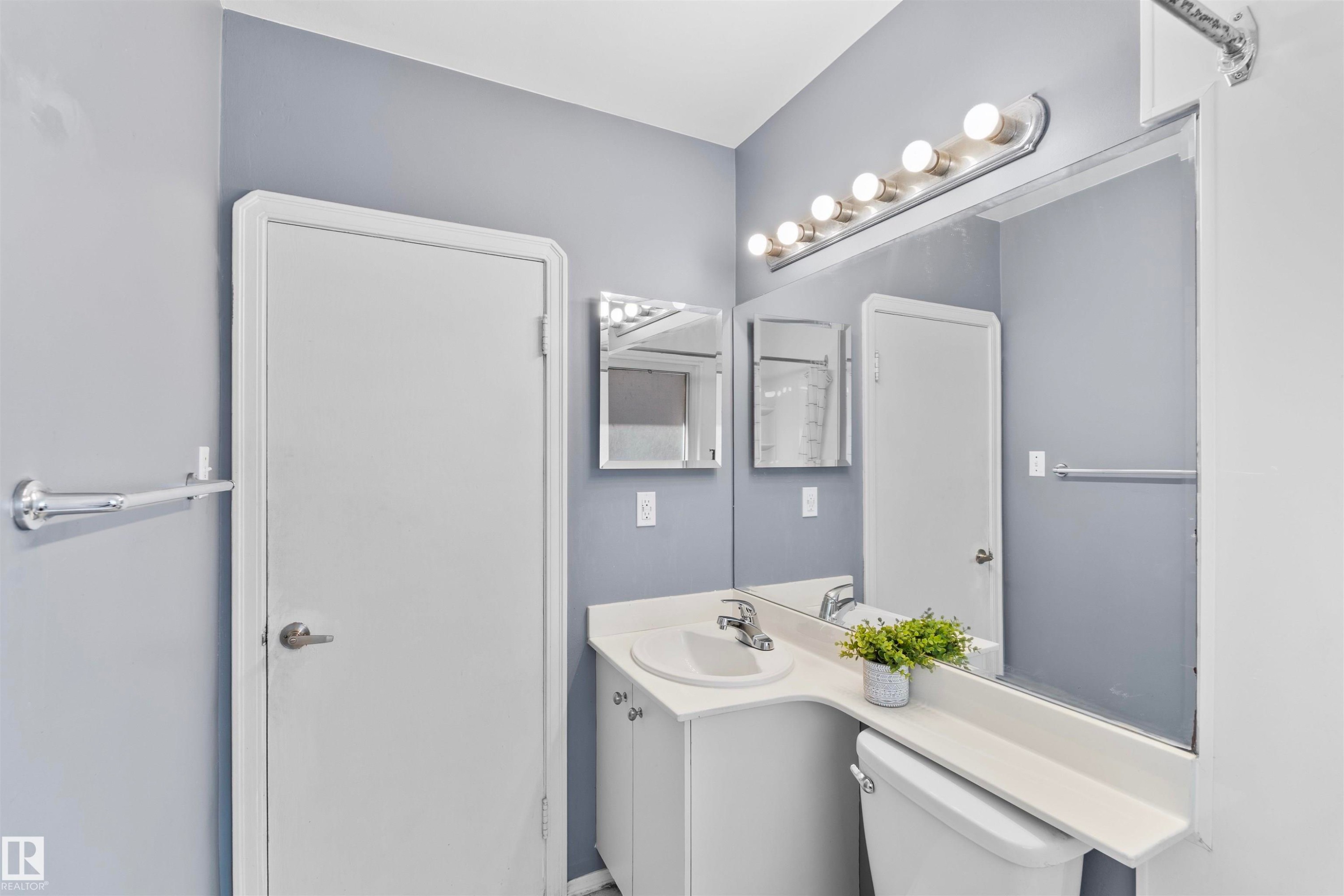 Bathroom vanity with an integrated sink and white cabinetry - 10607 73 Ave, Edmonton, AB