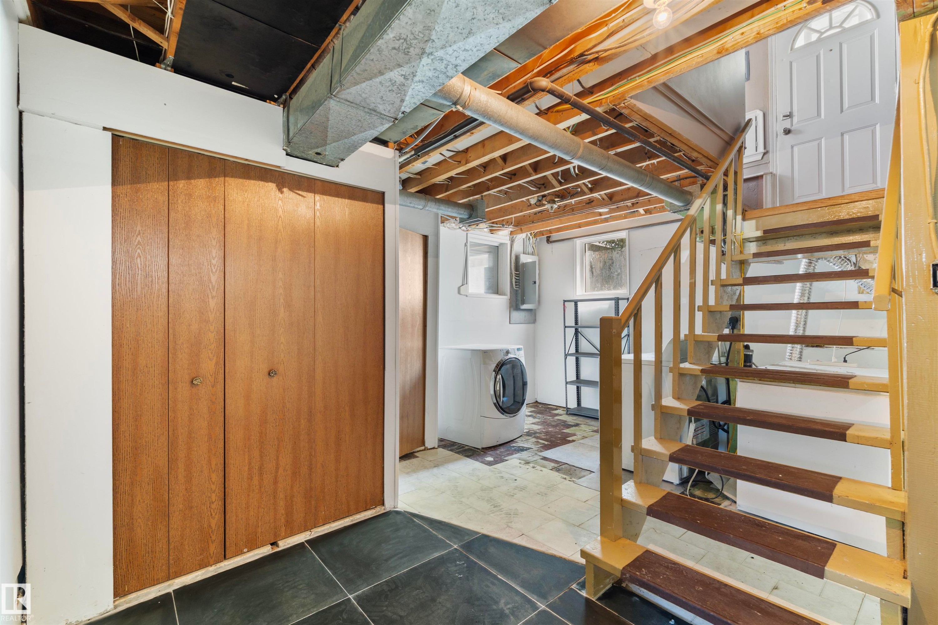 Staircase featuring wood risers and handrail, leading to an exterior door - 10607 73 Ave, Edmonton, AB