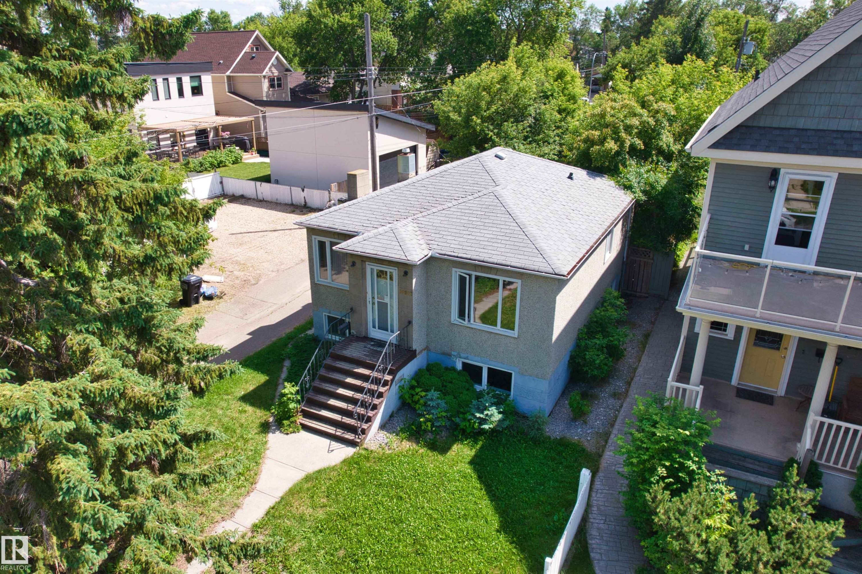 Single-story residence featuring a gray shingle roof, stucco exterior, and multiple windows - 10607 73 Ave, Edmonton, AB