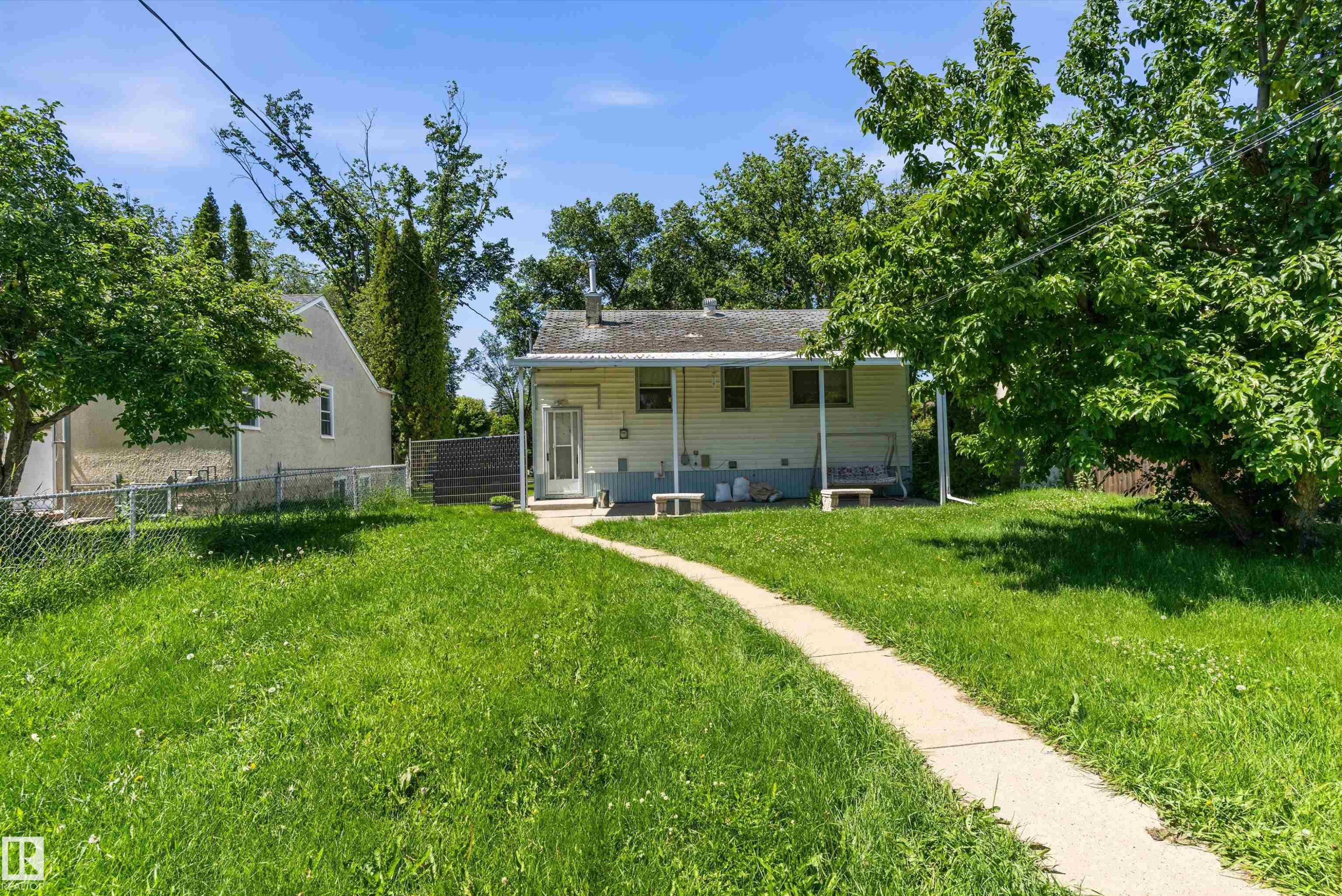 Single-story residence featuring a covered front porch and a light-colored exterior - 11619 123 Street, Edmonton, AB