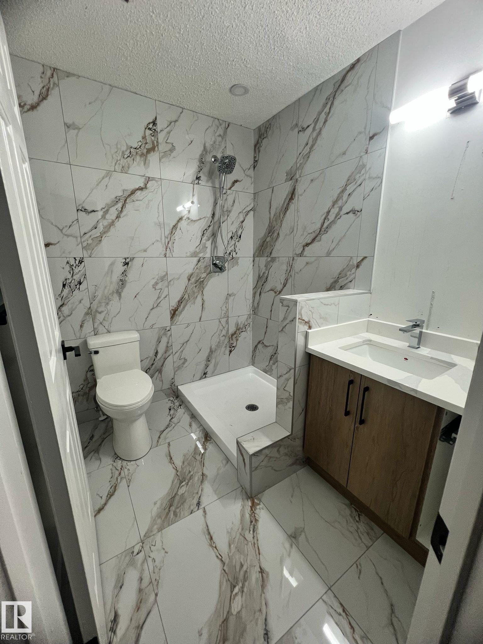 Bathroom featuring large format marble-look tile flooring and wall surround - 3320 43 Street, Edmonton, AB
