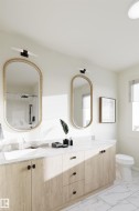Double vanity featuring wood-finish cabinetry with black hardware, two oval mirrors, and integrated lighting fixtures -