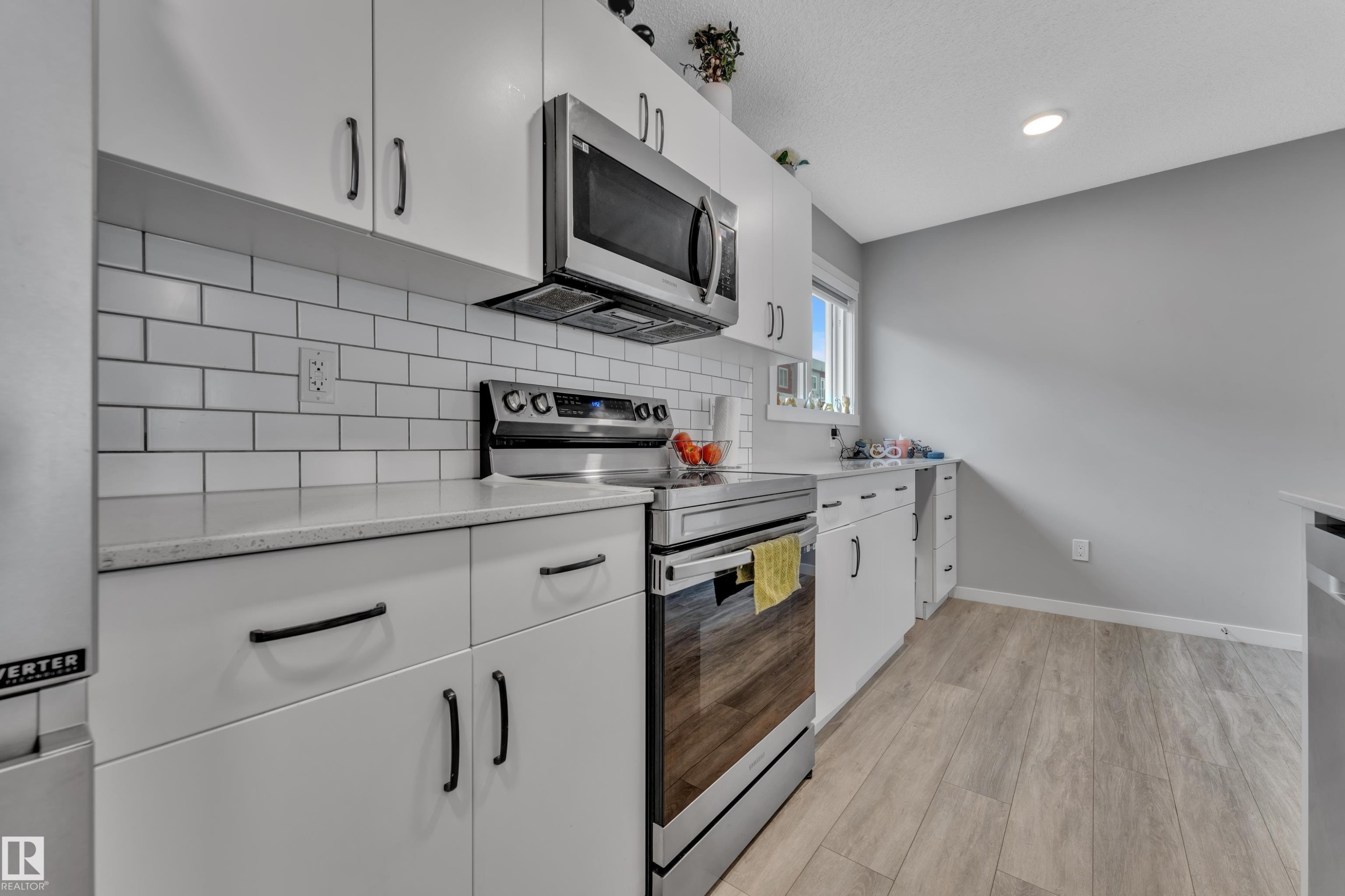 Modern kitchen with white cabinetry and stainless steel appliances - #82 1816 Rutherford Rd Sw, Edmonton, AB - Indoor Photo Showing Kitchen