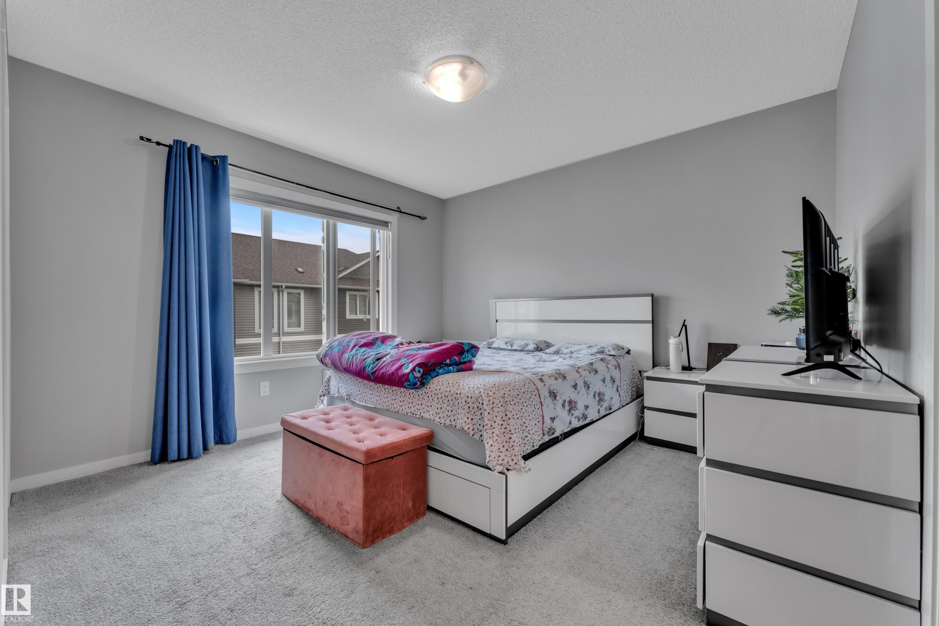 Carpeted room with a large window, providing natural light - #82 1816 Rutherford Rd Sw, Edmonton, AB - Indoor Photo Showing Bedroom