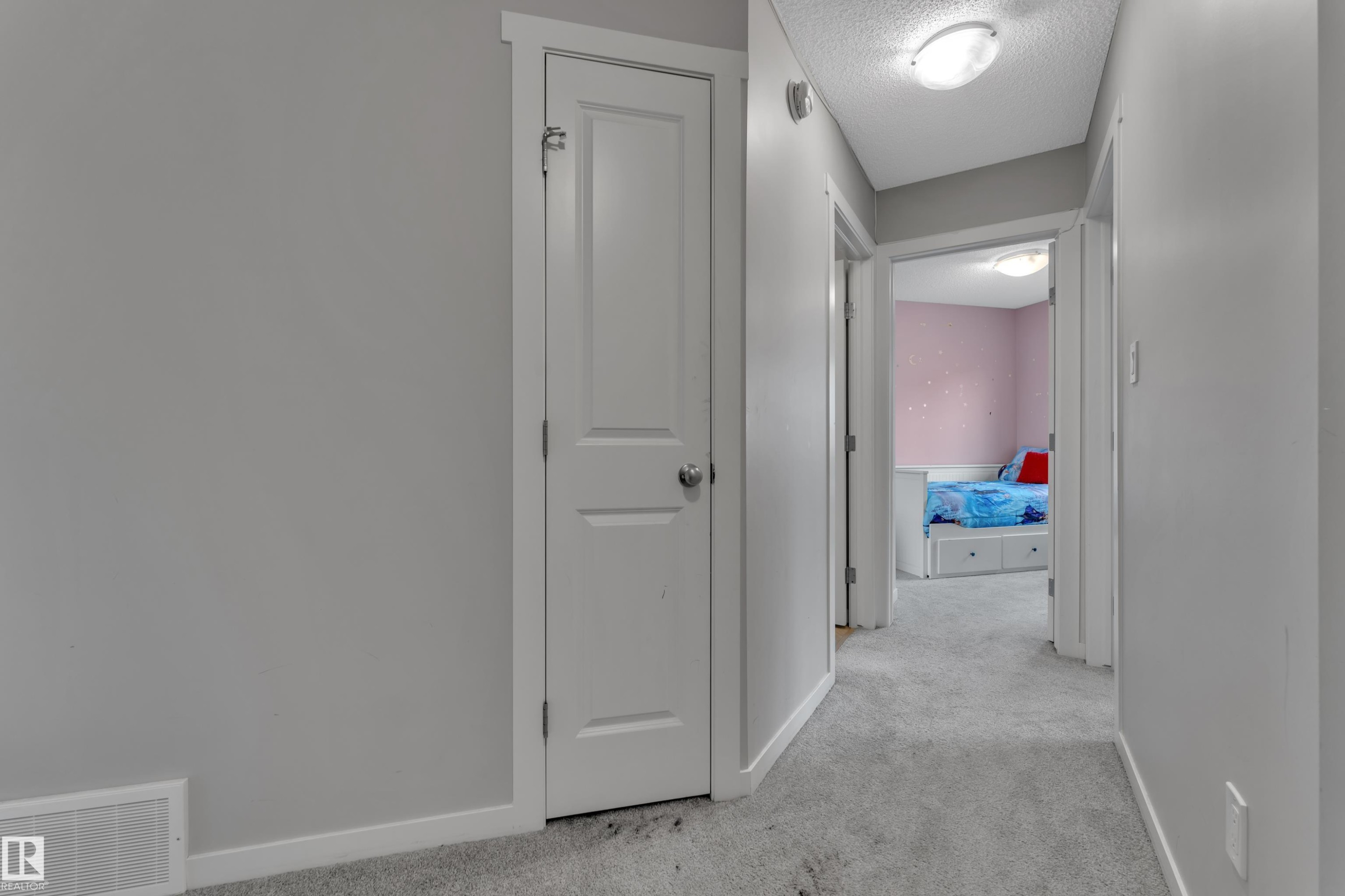Hallway featuring light gray walls, gray carpeting, white trim, and a flush mount ceiling light fixture - #82 1816 Rutherford Rd Sw, Edmonton, AB - Indoor Photo Showing Other Room