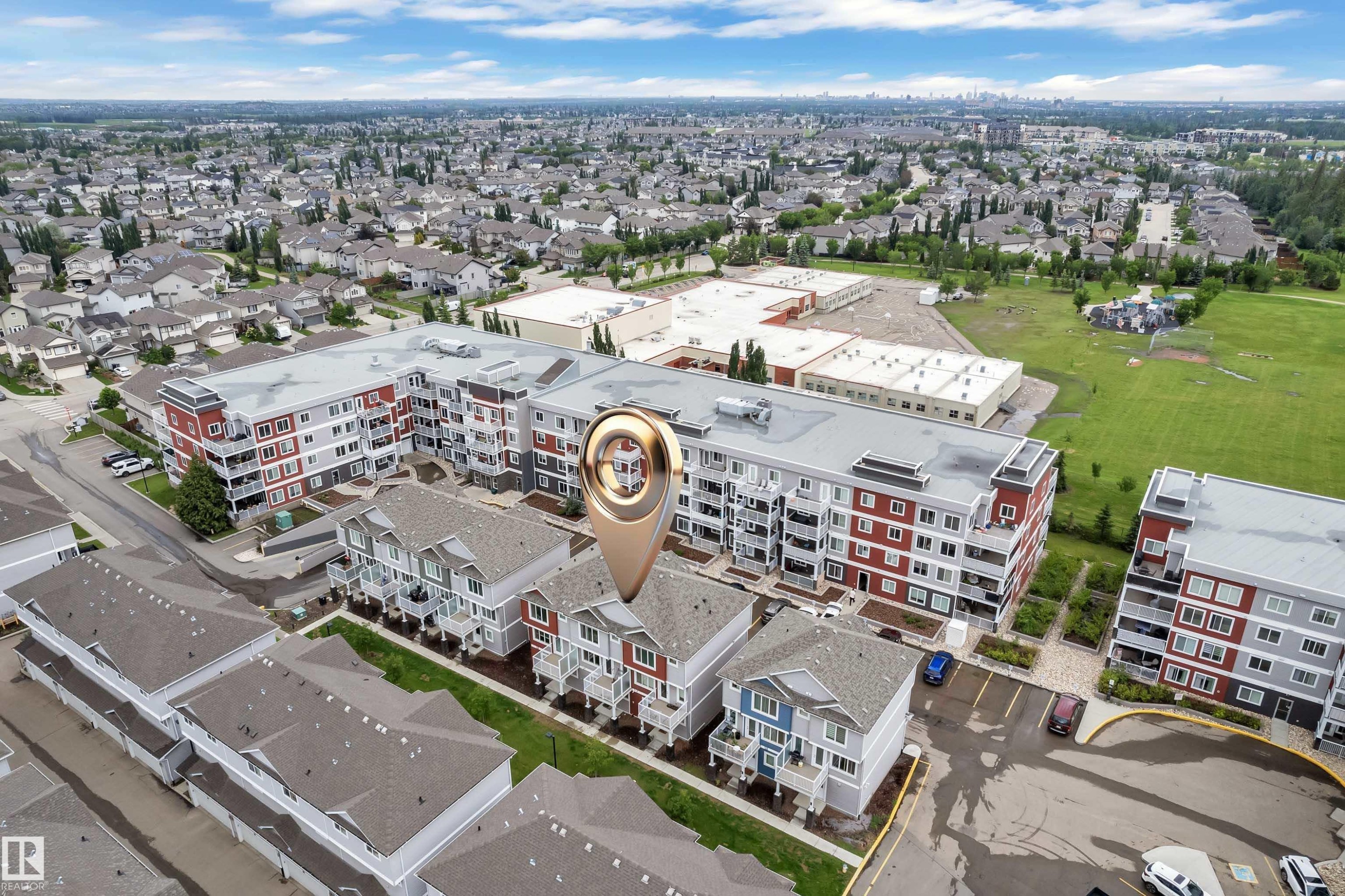 Aerial overview of a residential area featuring multi-story buildings with contrasting facades - #82 1816 Rutherford Rd Sw, Edmonton, AB - Outdoor With View