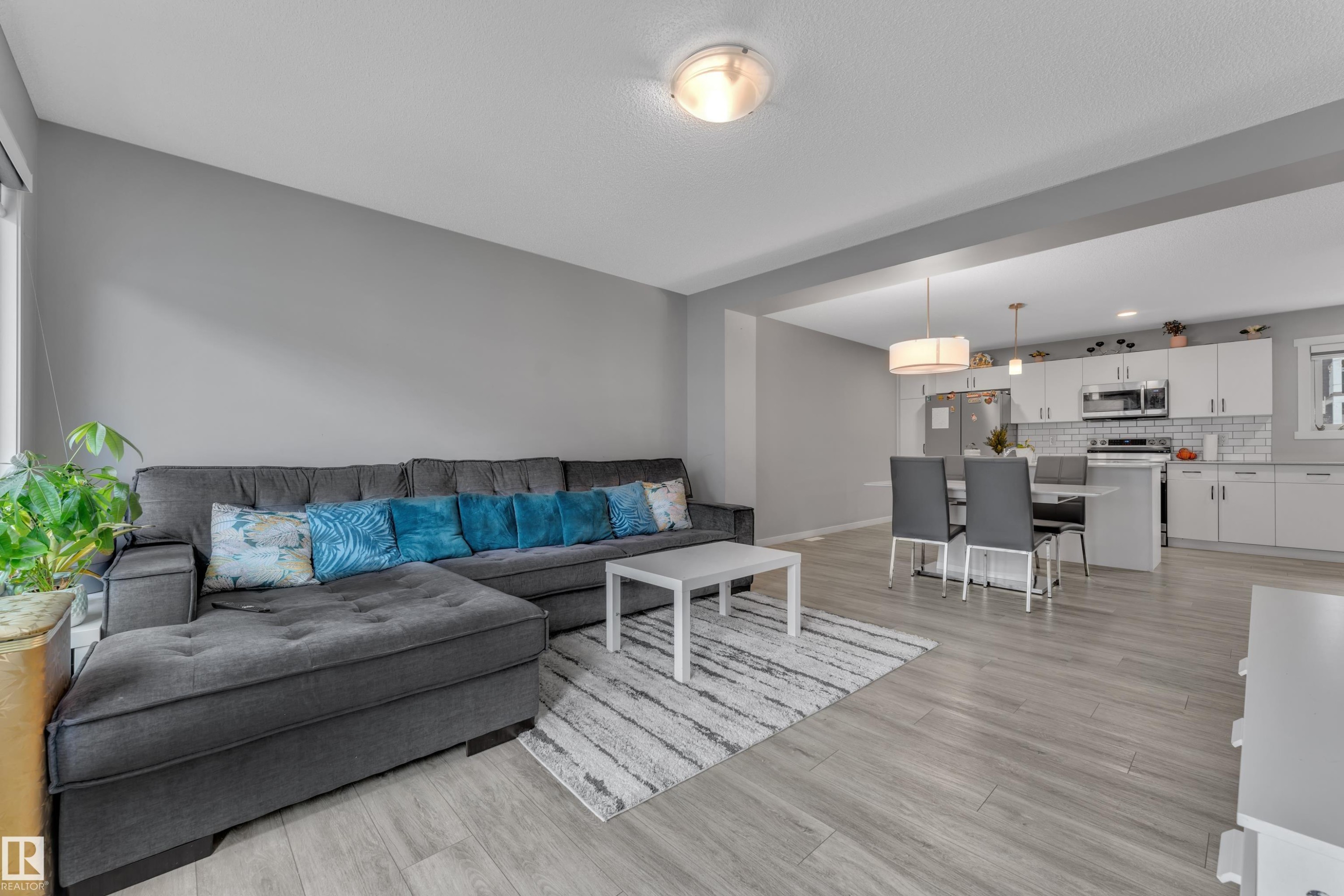 Open-concept living space featuring wood-finish flooring, recessed lighting, and a neutral wall palette - #82 1816 Rutherford Rd Sw, Edmonton, AB - Indoor Photo Showing Living Room