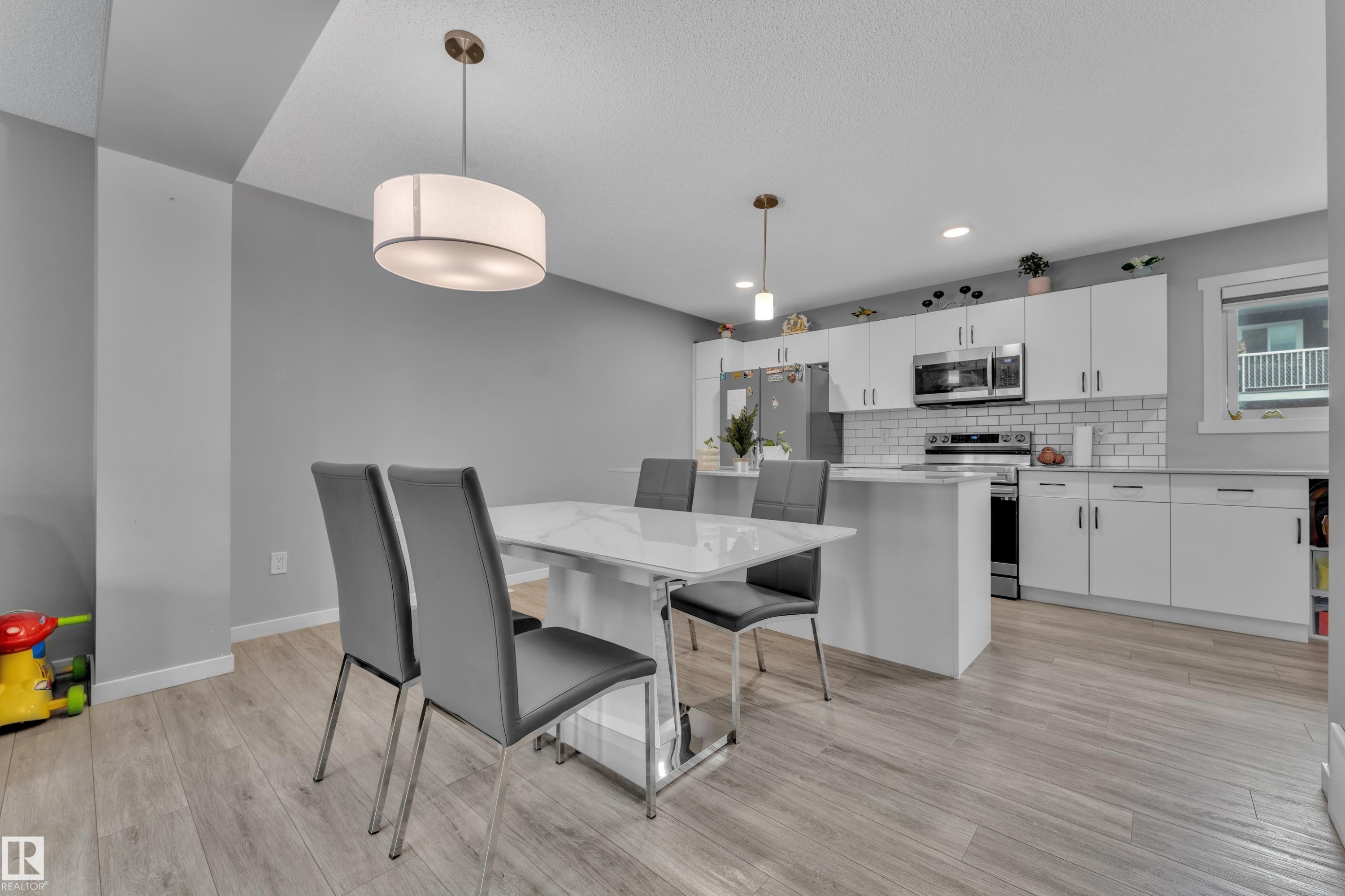 Modern kitchen with white cabinetry and stainless steel appliances - #82 1816 Rutherford Rd Sw, Edmonton, AB - Indoor