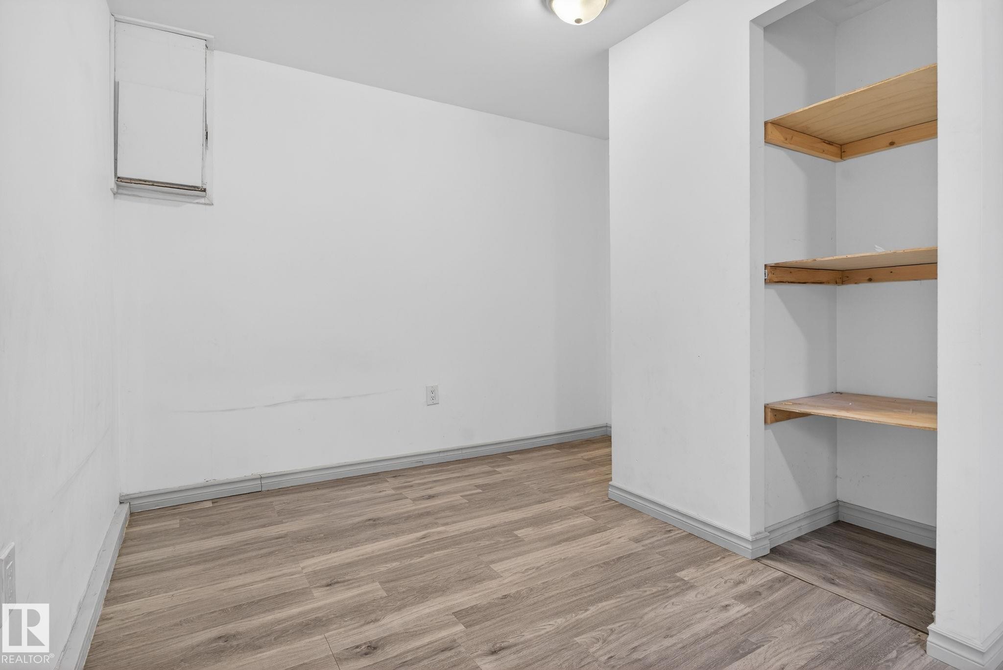 Room featuring wood-finish flooring, white walls, and built-in shelving - 543 Evergreen Park Northwest, Edmonton, AB - Indoor