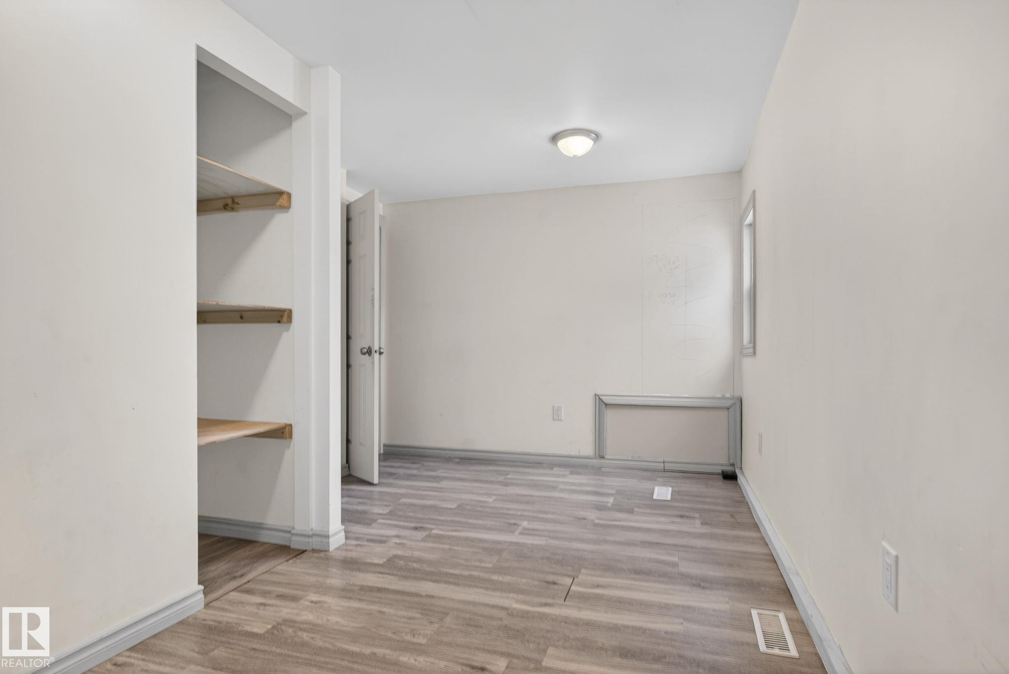 Room featuring wood-finish flooring, a neutral color palette, and a built-in shelving unit - 543 Evergreen Park Northwest, Edmonton, AB - Indoor