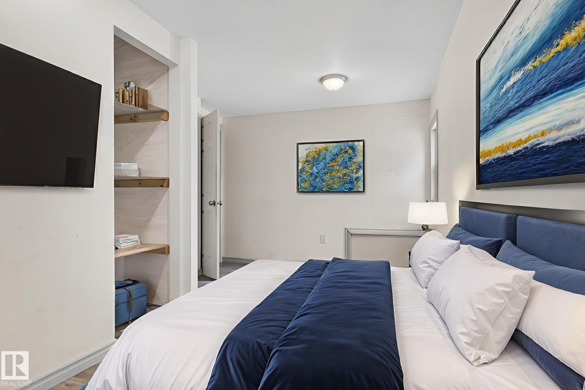 Bedroom featuring a built-in shelving unit with wood shelves, light-toned walls, recessed ceiling lighting, and light wood-finish flooring - 543 Evergreen Park Northwest, Edmonton, AB - Indoor Photo Showing Bedroom
