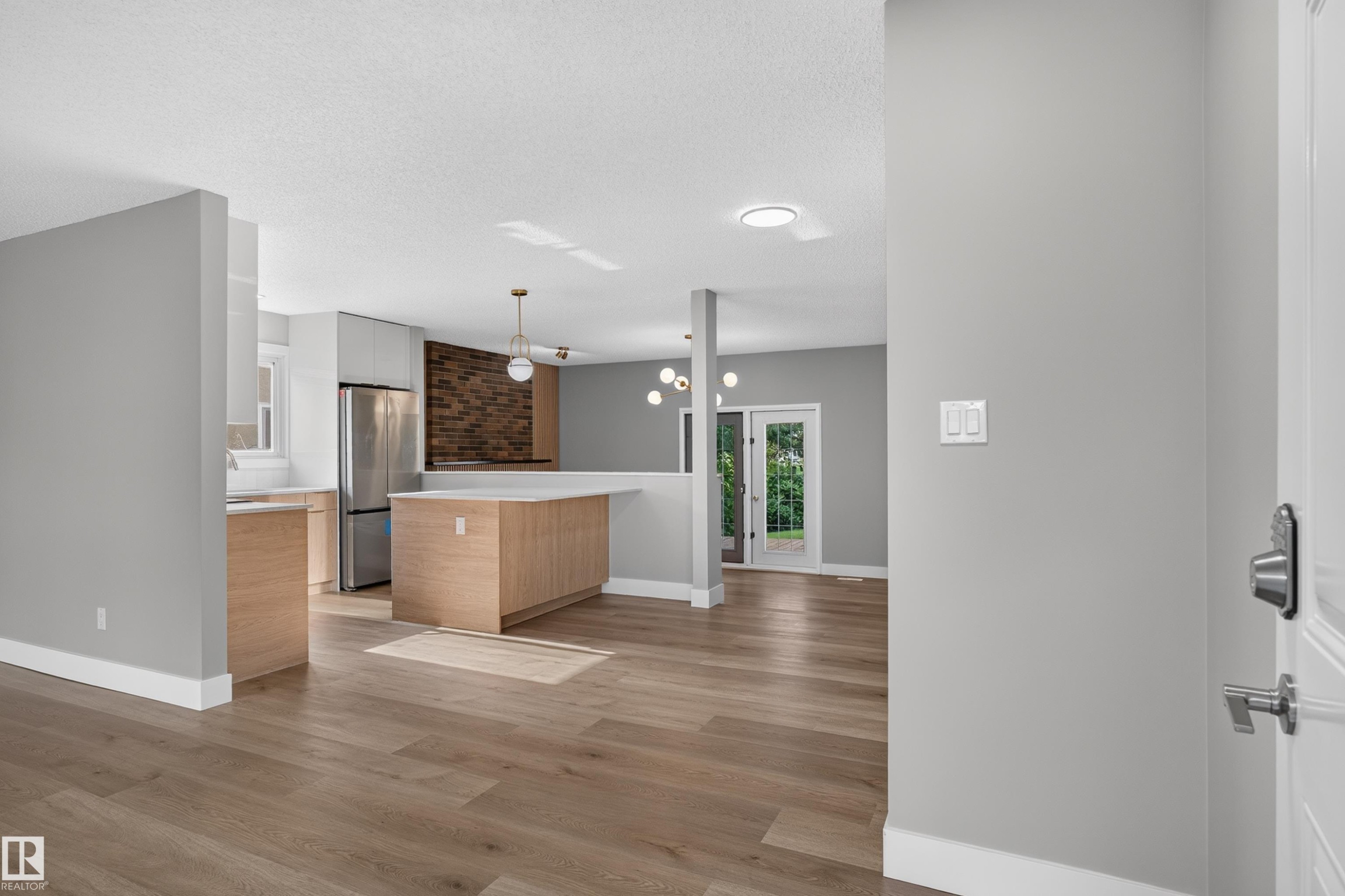 Contemporary kitchen and living area featuring wood-finish flooring - 33 Brookside Avenue, Spruce Grove, AB