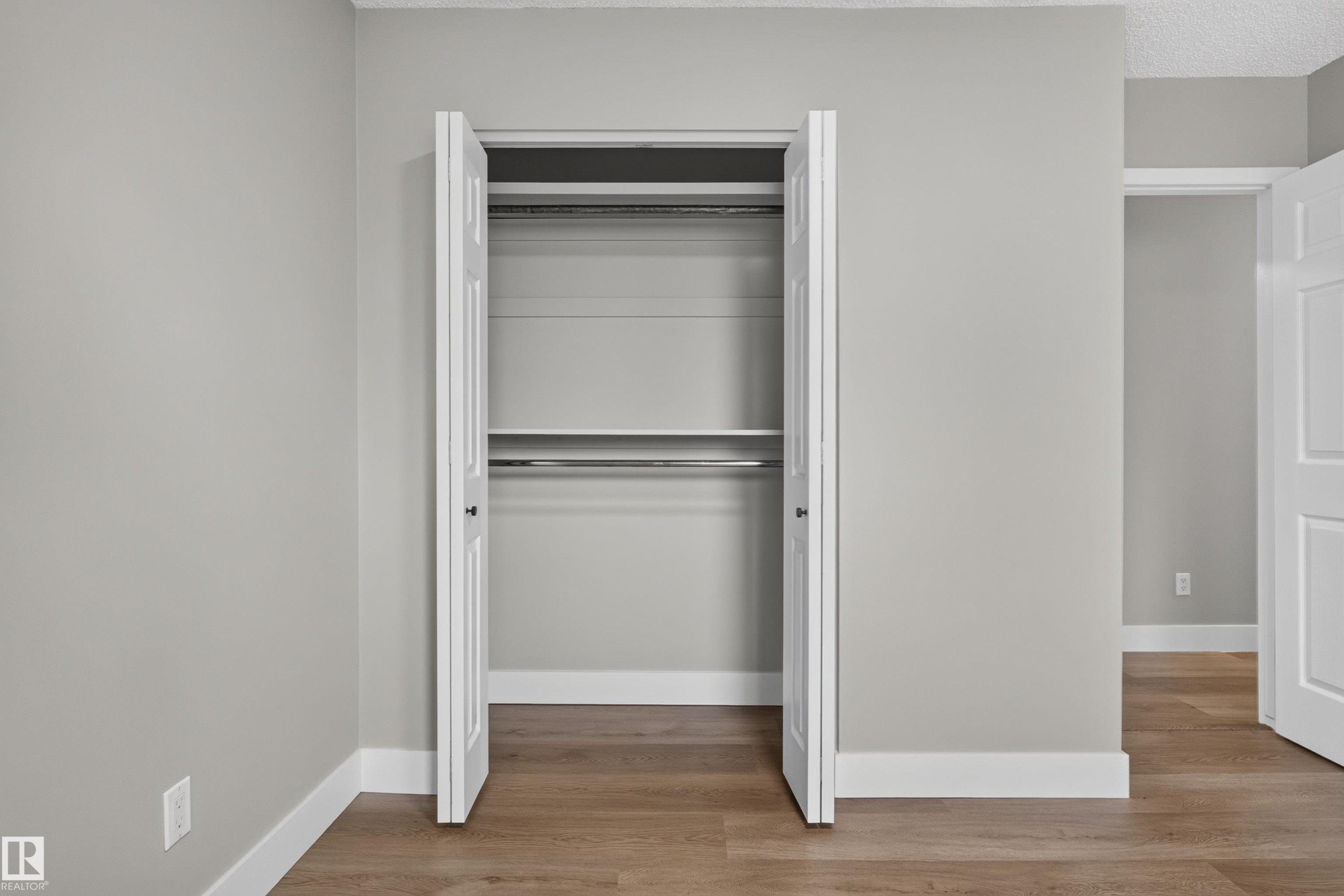 Double-door closet featuring a built-in shelf and two hanging rods - 33 Brookside Avenue, Spruce Grove, AB