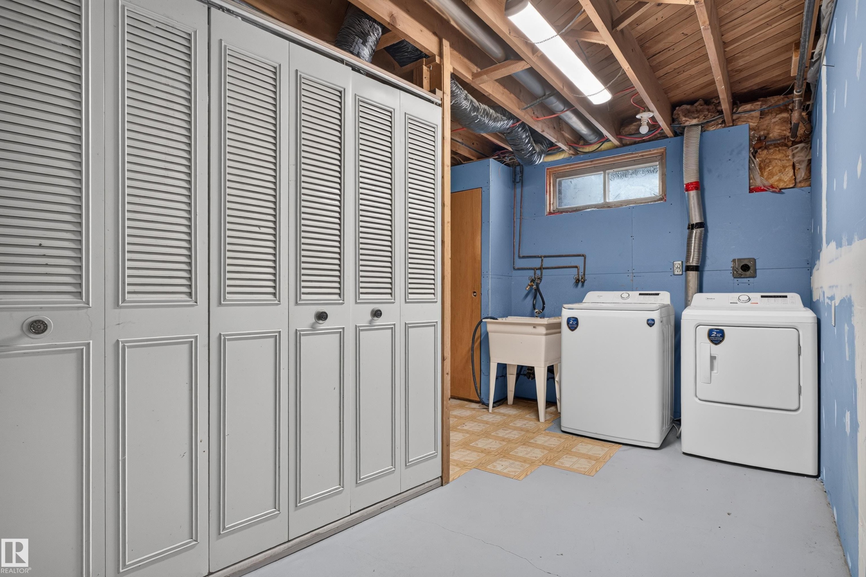 Laundry area featuring a washer, dryer, utility sink, and overhead fluorescent lighting - 33 Brookside Avenue, Spruce Grove, AB