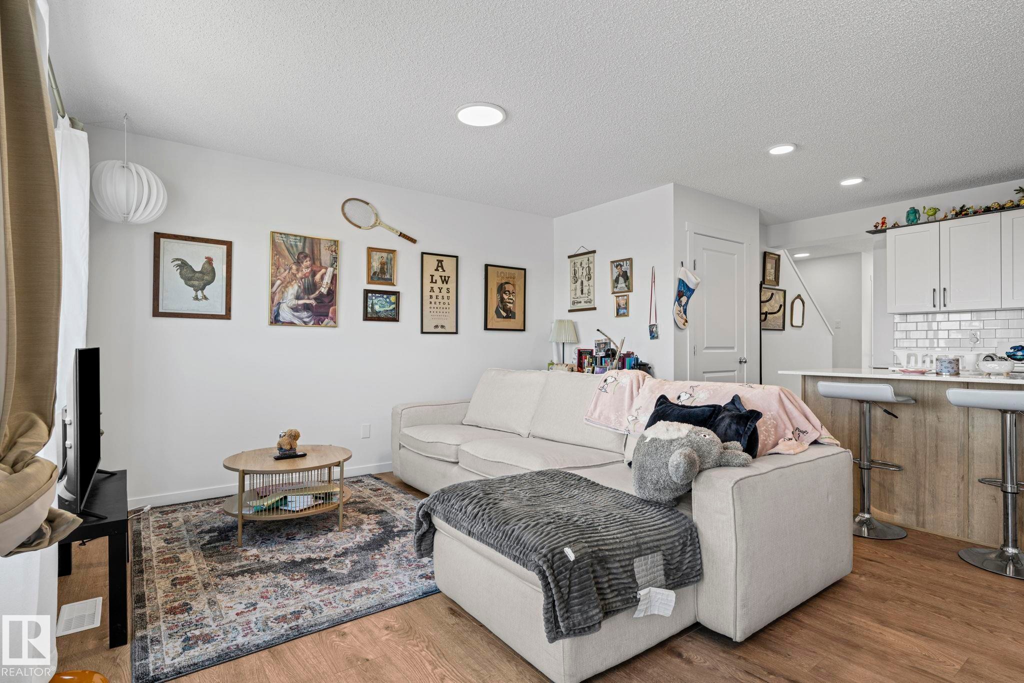 Living area featuring recessed lighting, wood-finish flooring, and an open concept layout - 16 19904 31 Avenue, Edmonton, AB