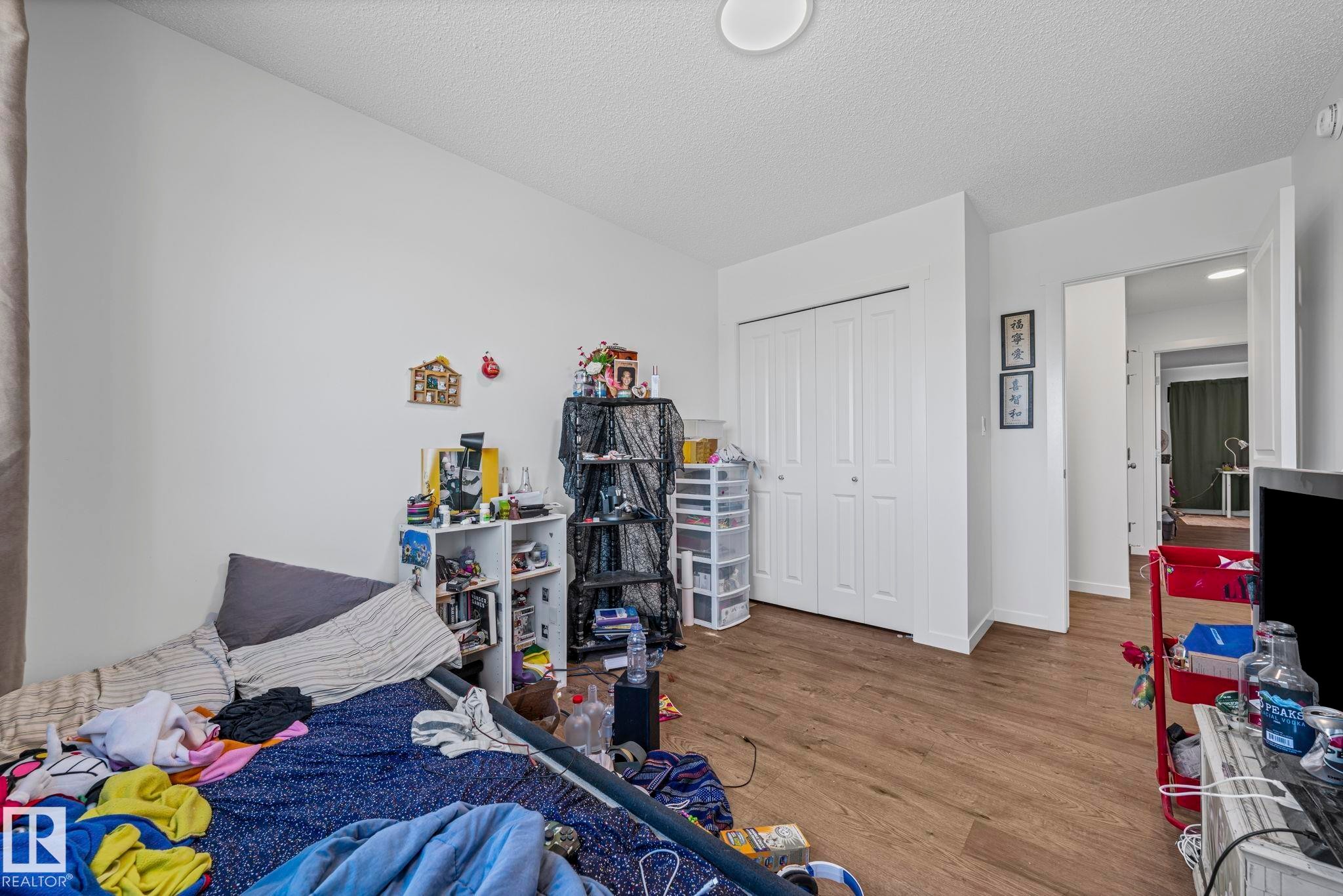 Room featuring wood-finish flooring, white walls, and a ceiling-mounted light fixture - 16 19904 31 Avenue, Edmonton, AB
