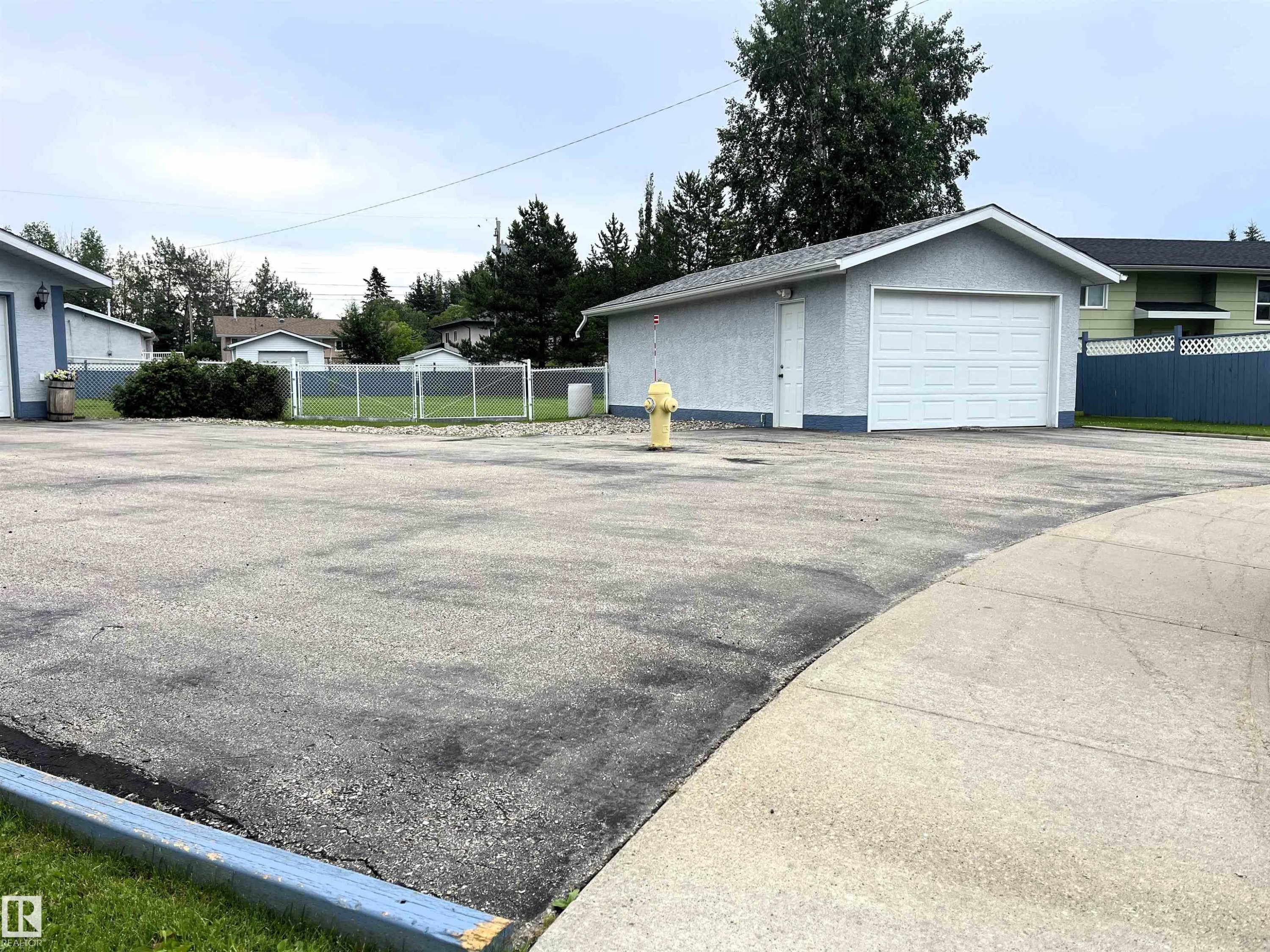 Detached garage with white overhead door and stucco exterior - 4914 51 Ave, Entwistle, AB