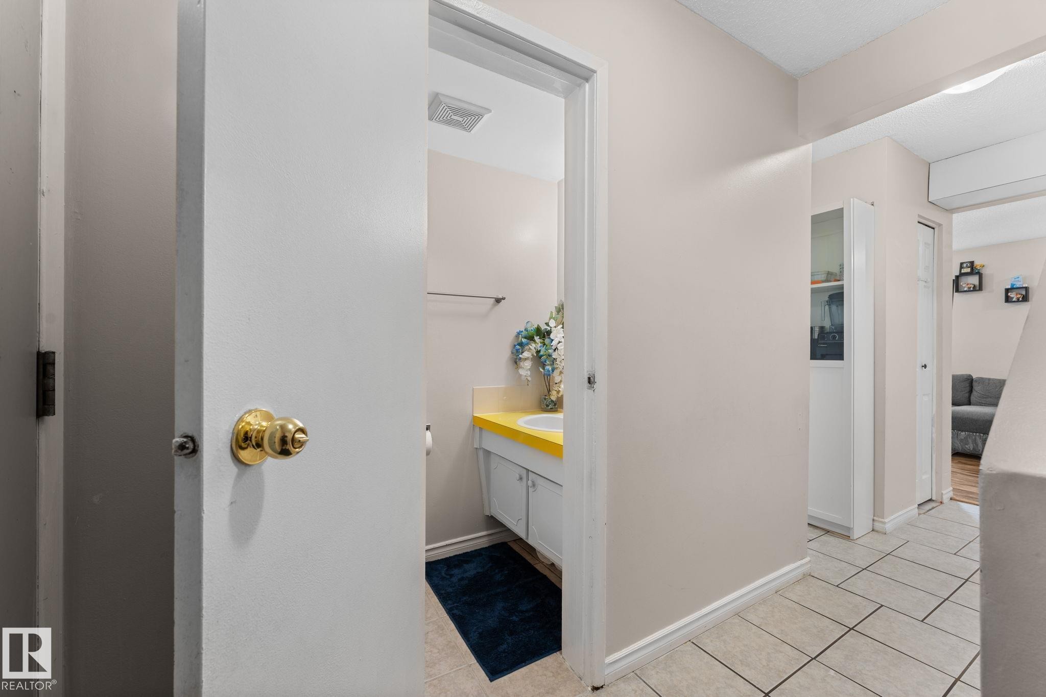 Powder room featuring a single vanity with a yellow countertop, white cabinetry, and a chrome faucet - 359 Northgate Terrace, Edmonton, AB