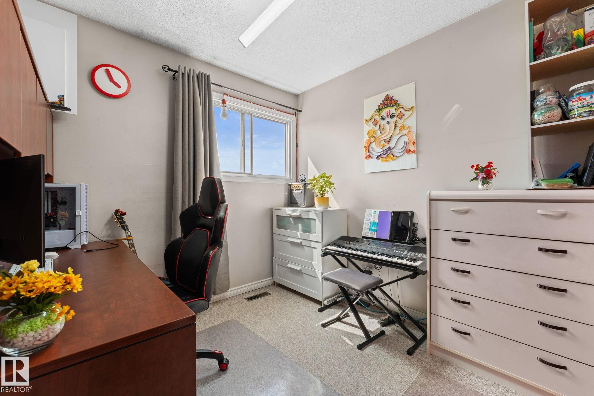 Windowed room featuring wood-finish built-in cabinetry, neutral wall paint, and light-toned carpet flooring - 359 Northgate Terrace, Edmonton, AB