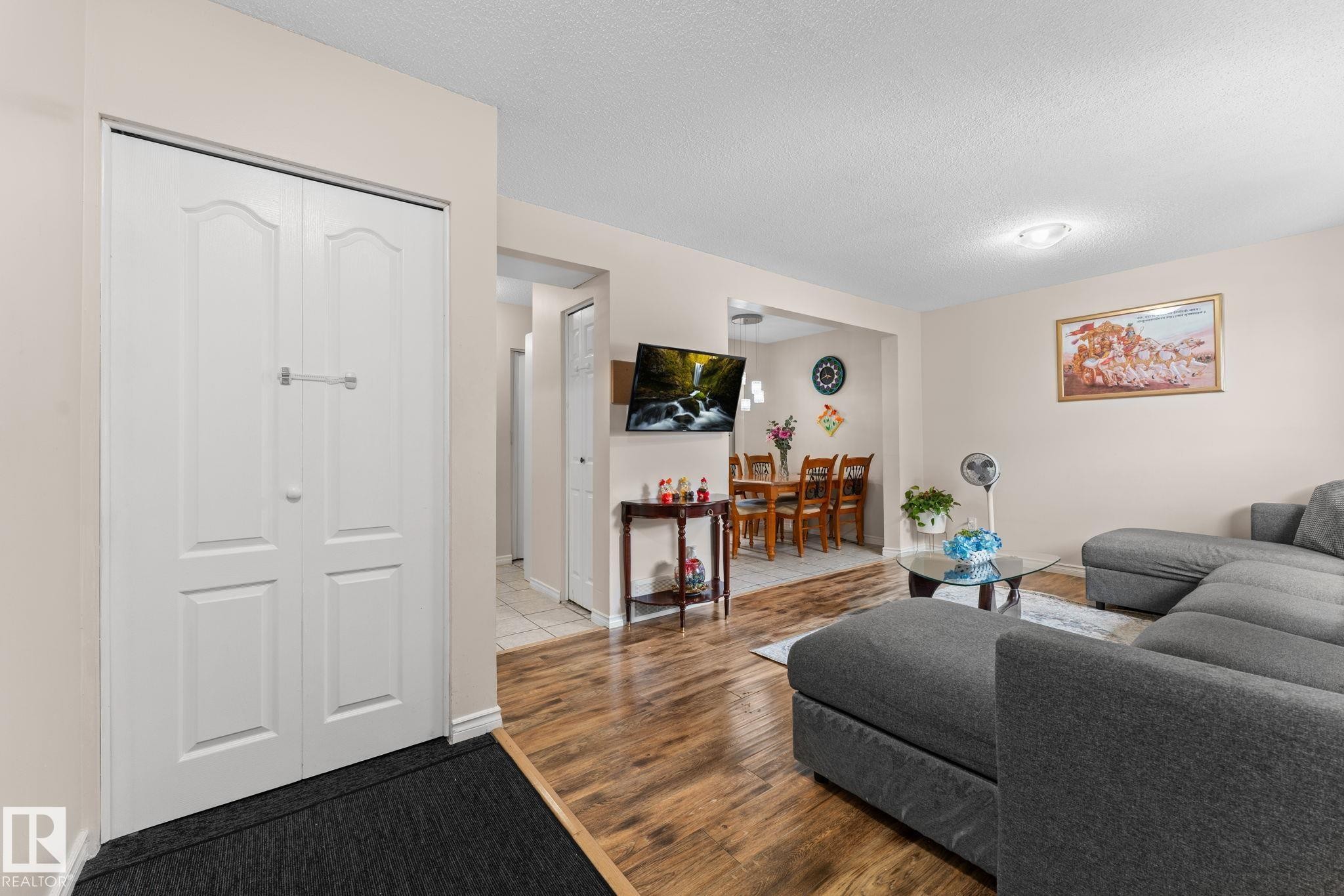 Open-concept living area with wood-finish flooring extending into the dining space - 359 Northgate Terrace, Edmonton, AB