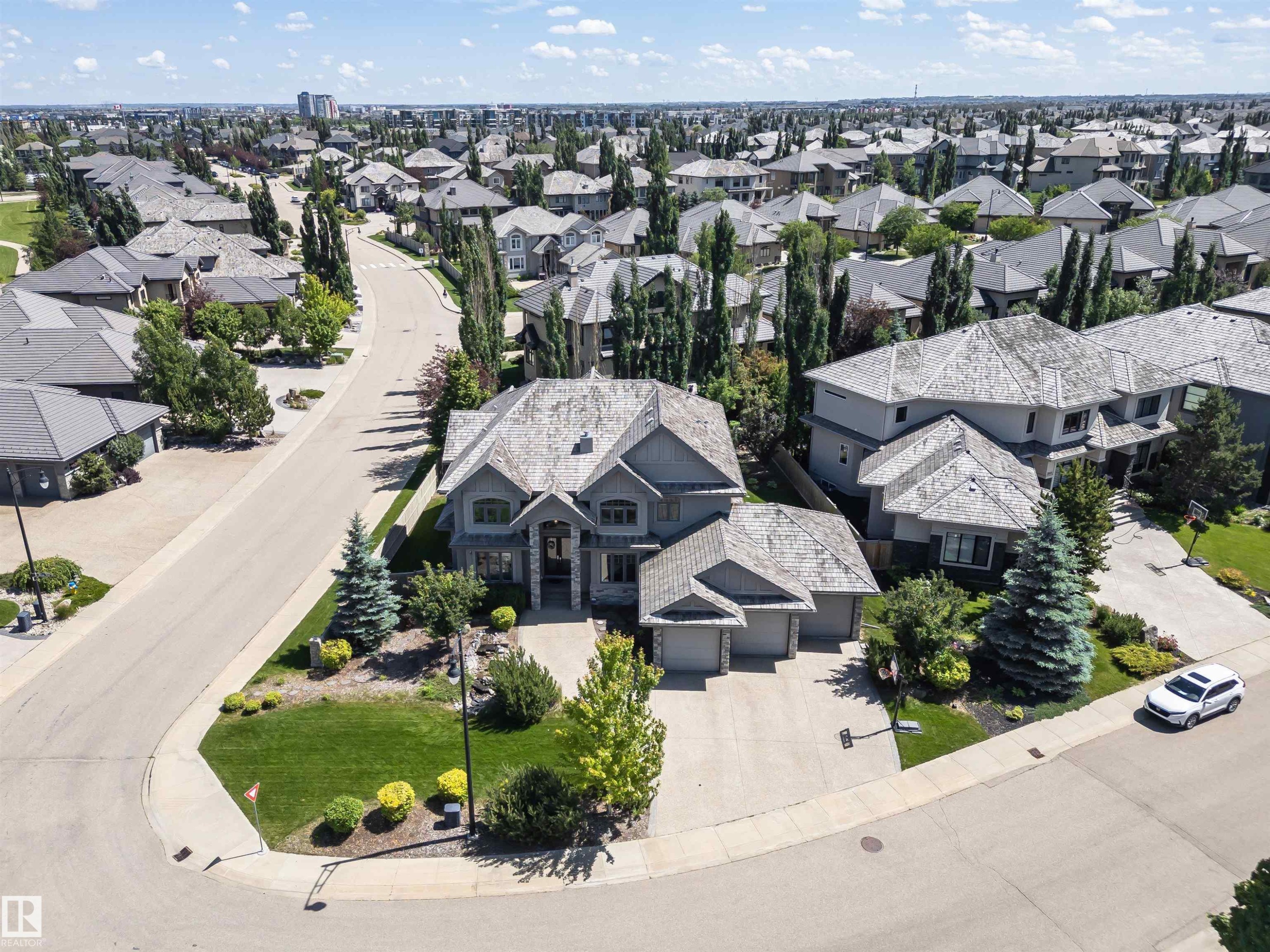 Spacious residential property featuring a stone and siding exterior, multi-car garage, and a gabled roofline - 3503 Watson Point(E), Edmonton, AB